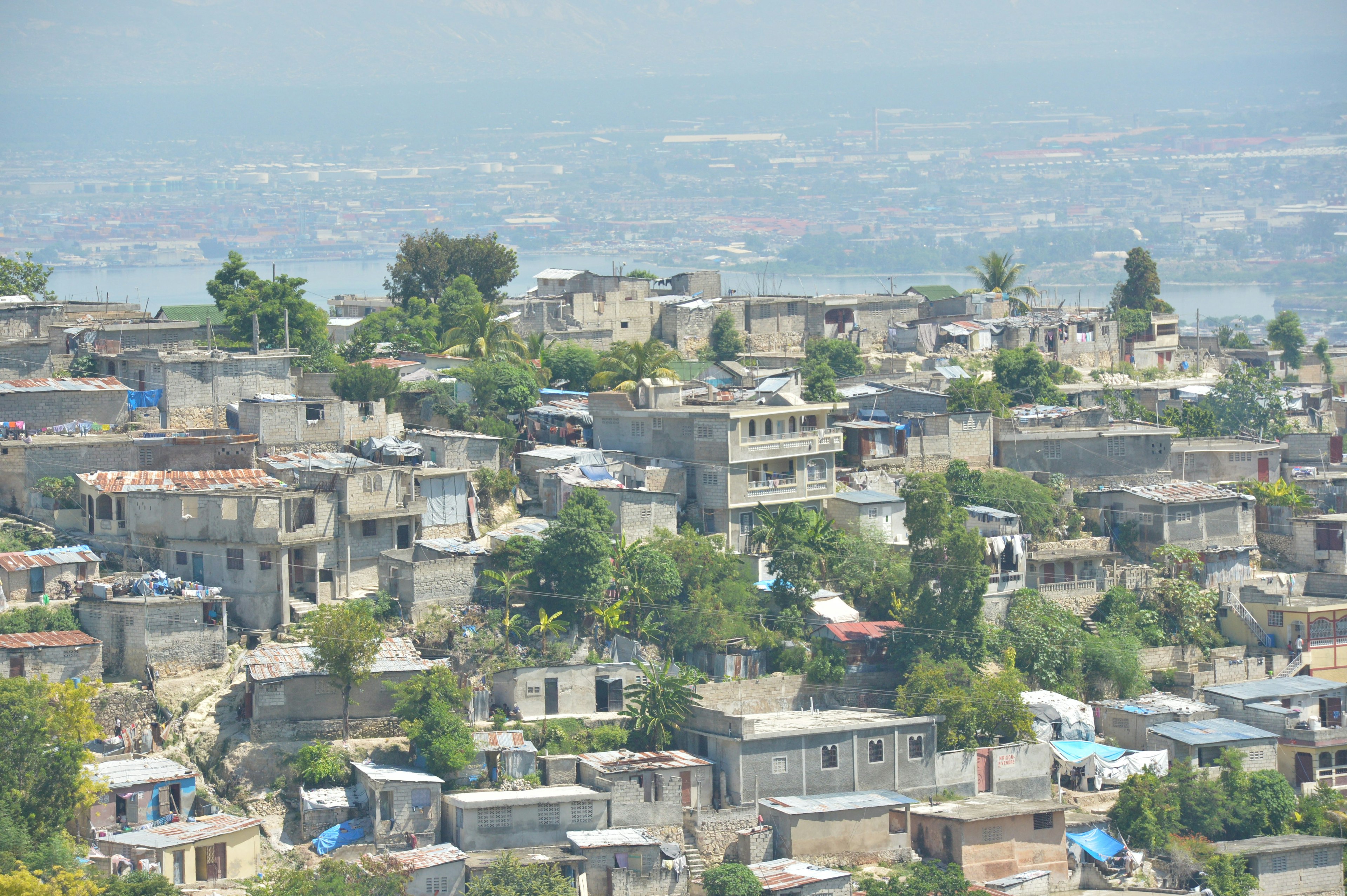 Vista di case densamente popolate ad Haiti circondate da verde da una collina