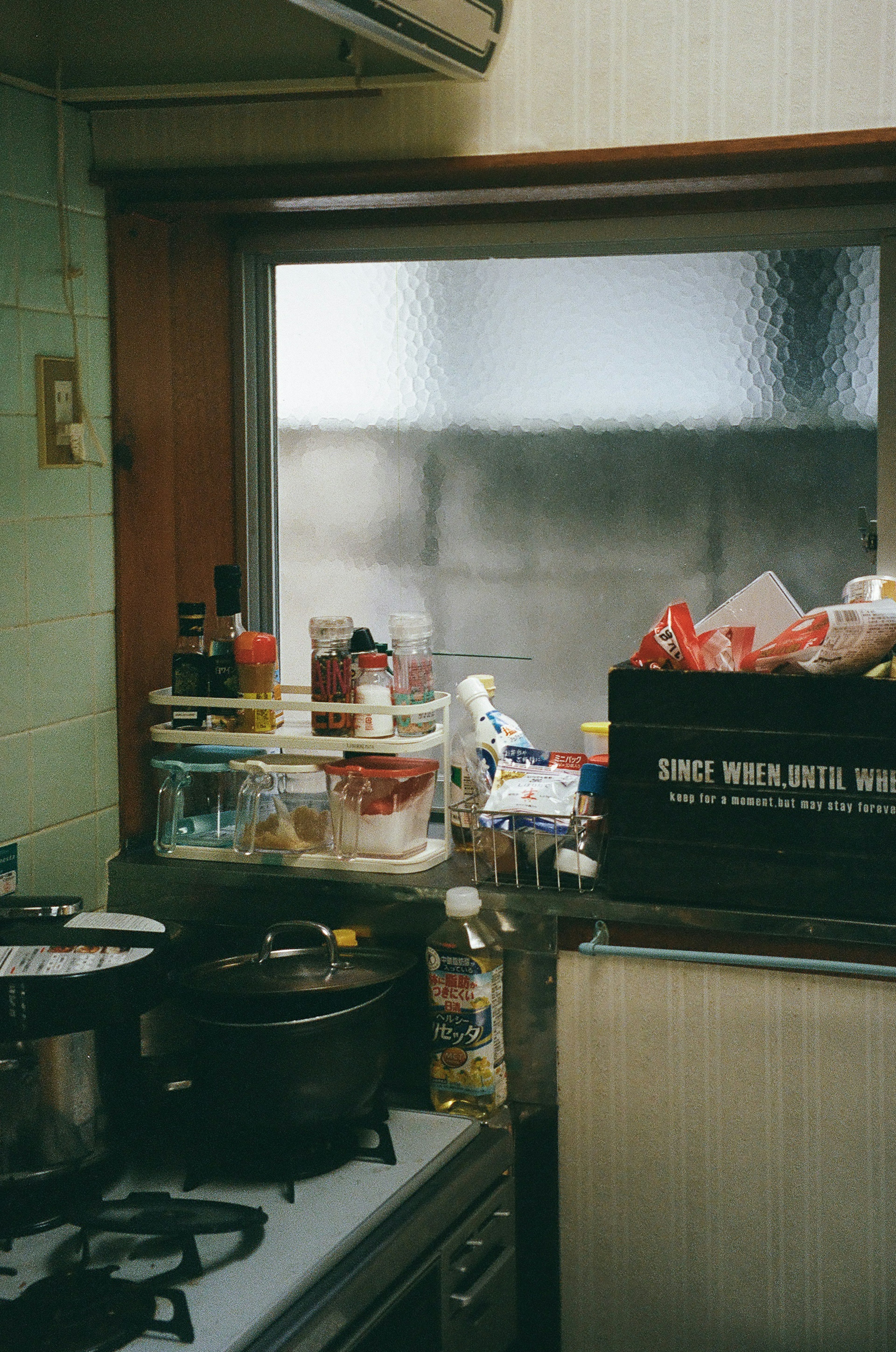 Interno di una cucina accogliente con utensili da cucina e condimenti visibili attraverso una finestra