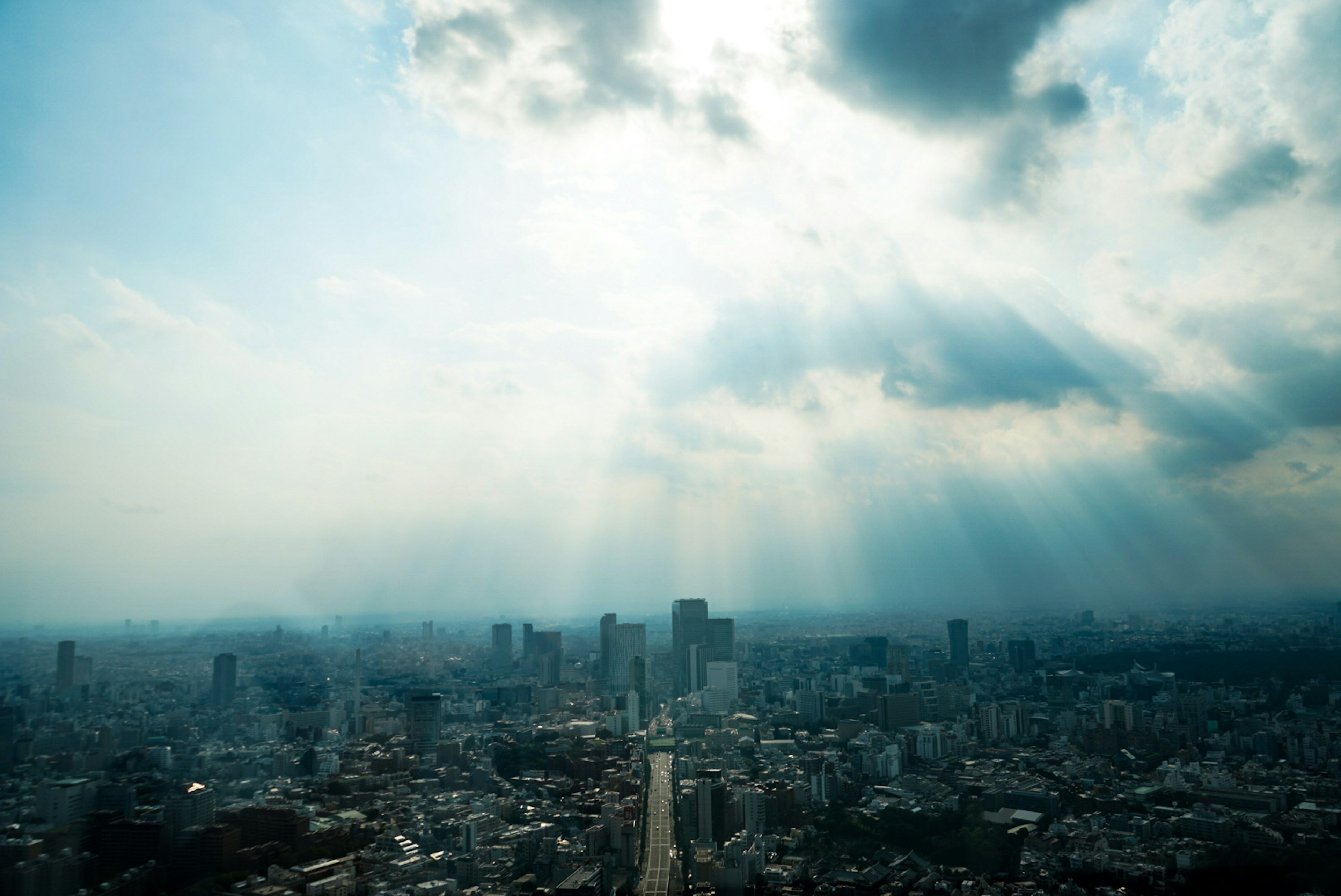 都市の上空からの日差しが差し込む風景