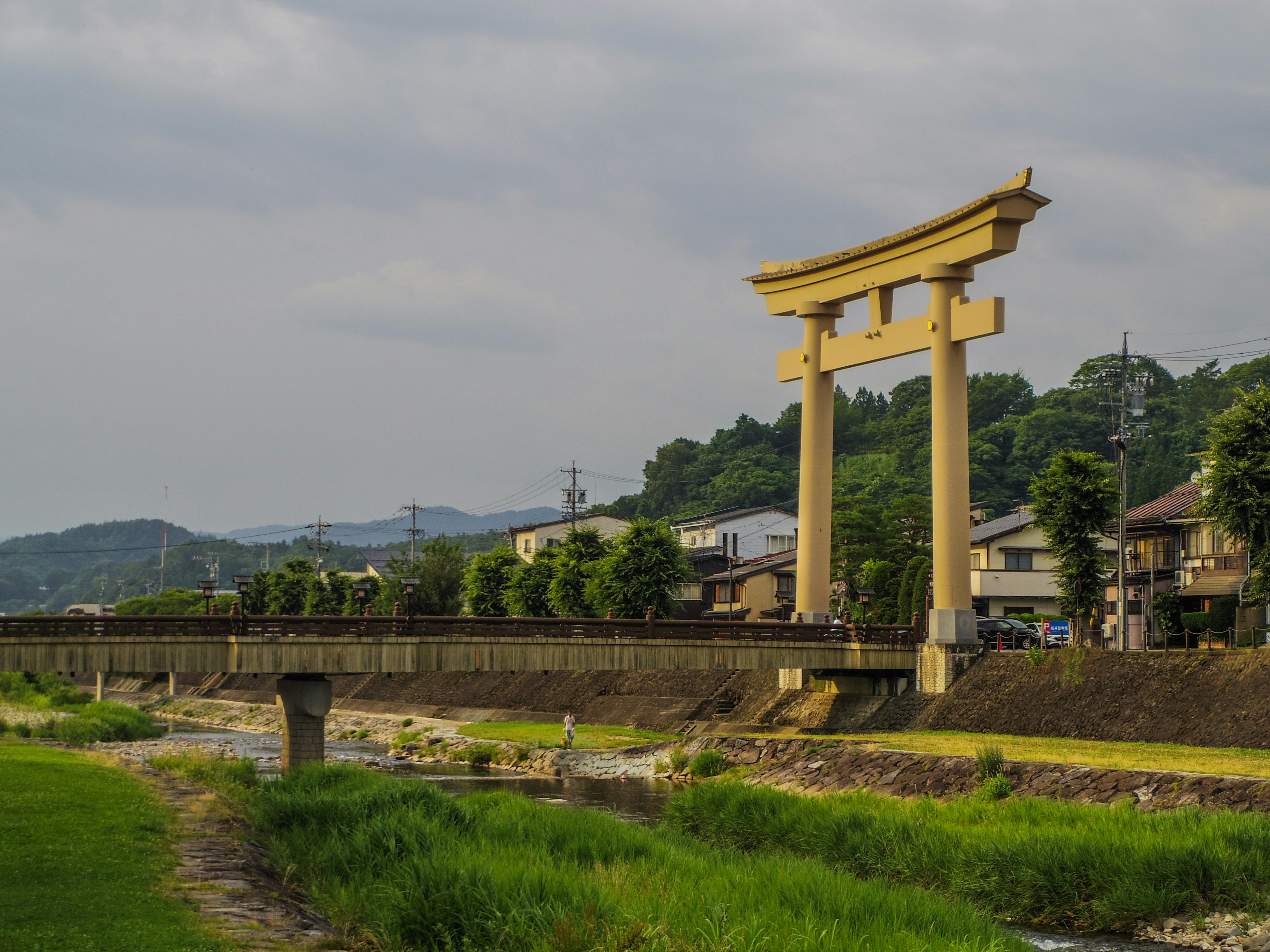 Großer Torii-Bogen in der Nähe eines Flusses umgeben von üppigem Grün