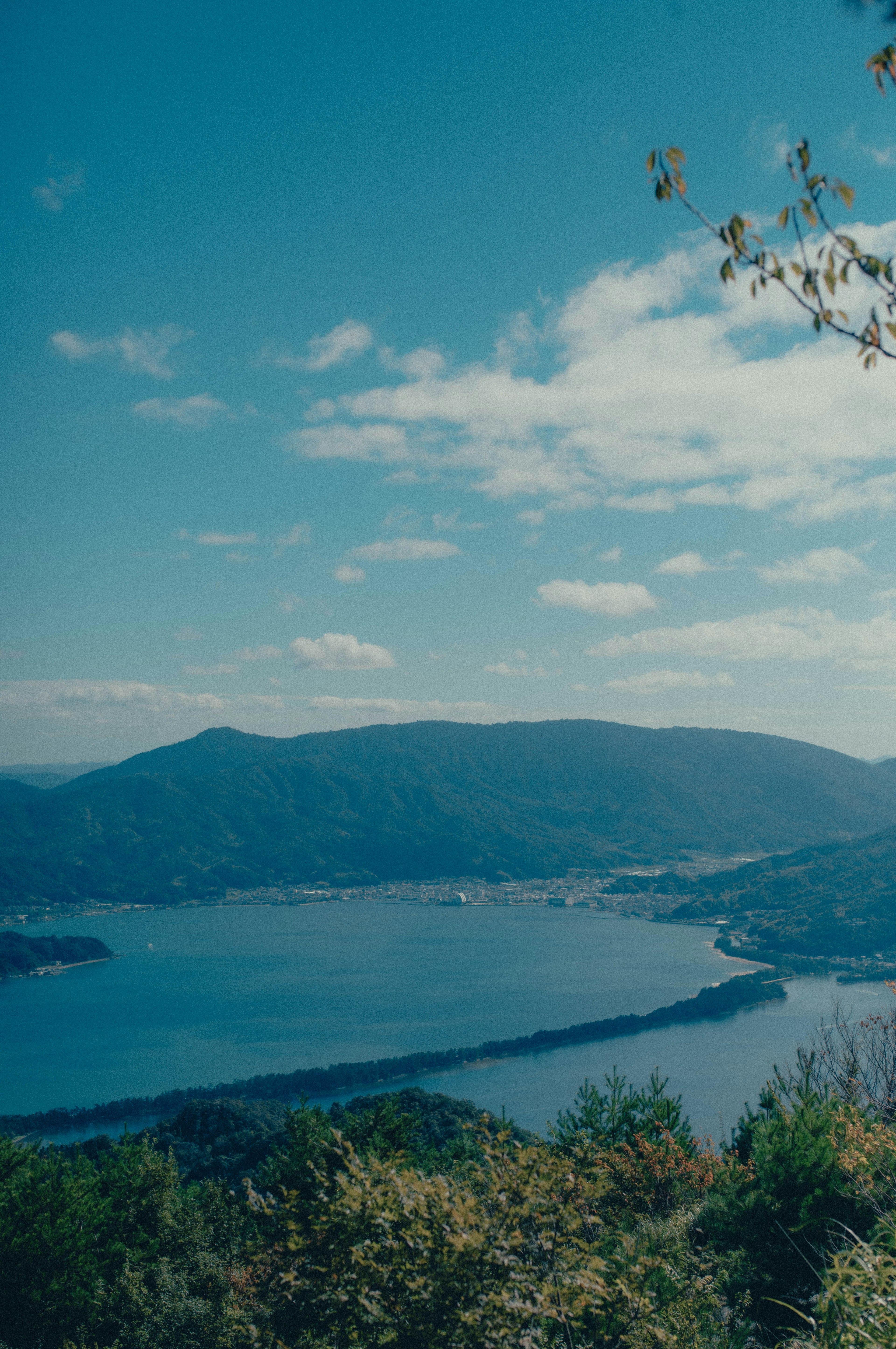 Vista panoramica di montagne e lago sotto un cielo azzurro