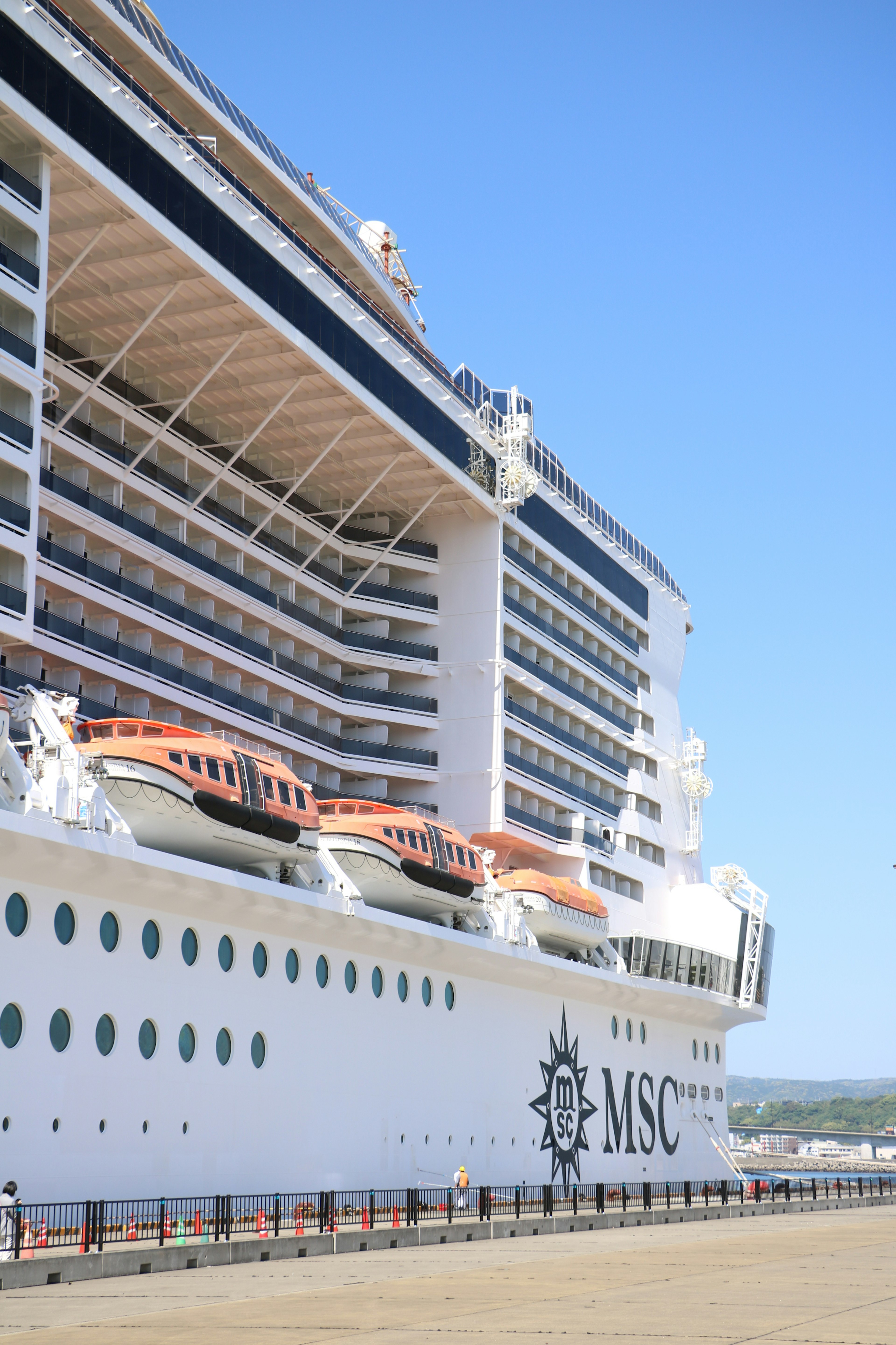 Side view of an MSC cruise ship docked under a clear blue sky