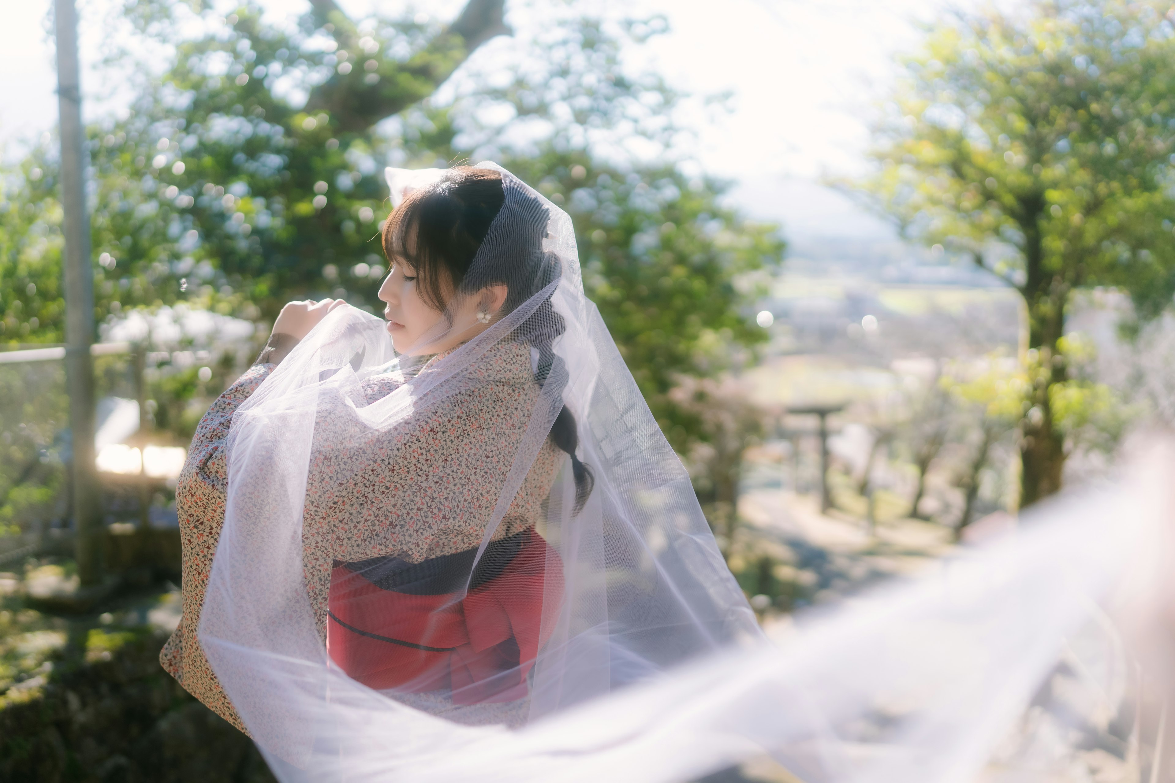 Femme dans un cadre serein tenant un tissu translucide entouré de nature