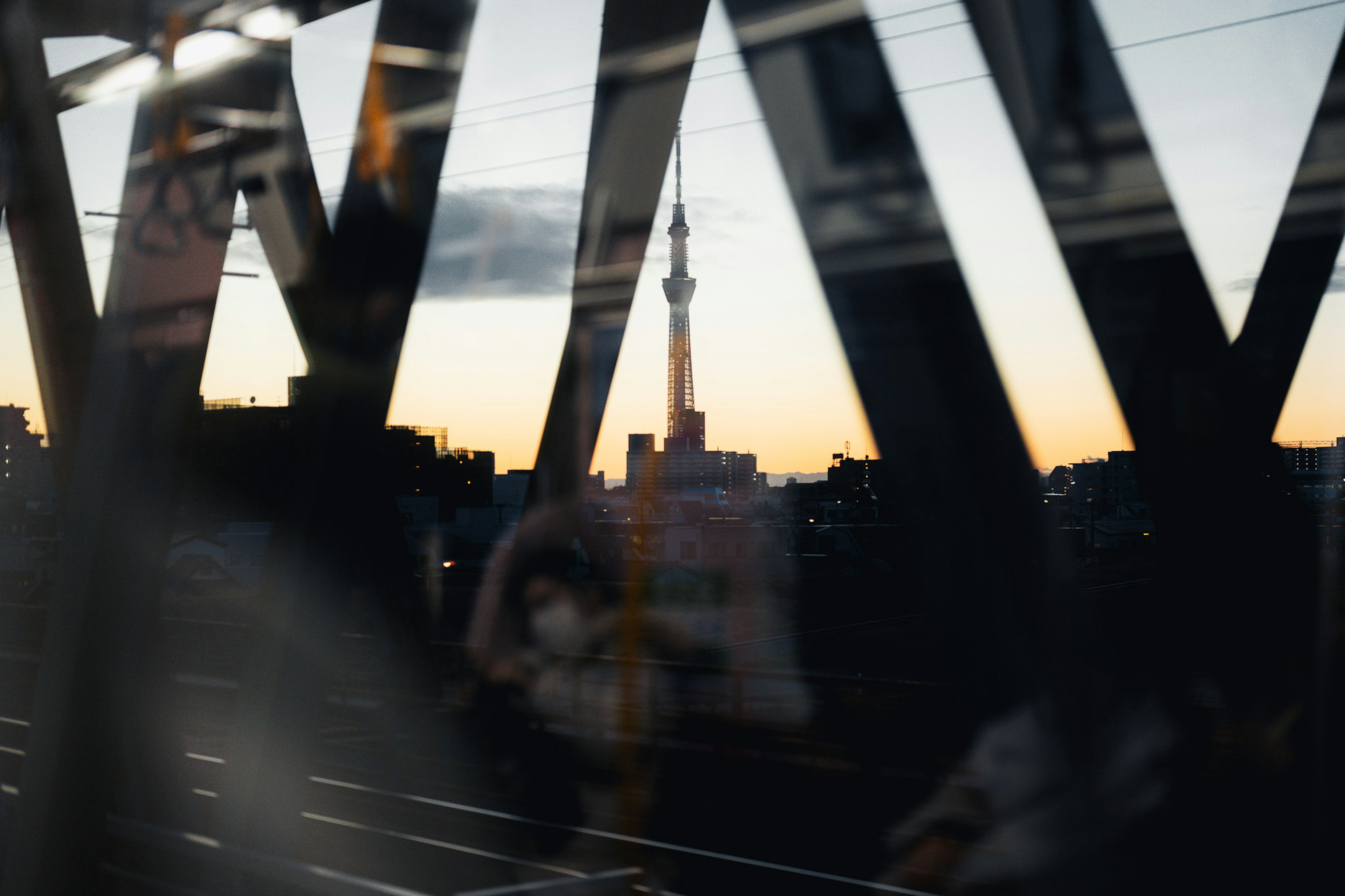 東京スカイツリーが夕暮れに映る窓越しの風景