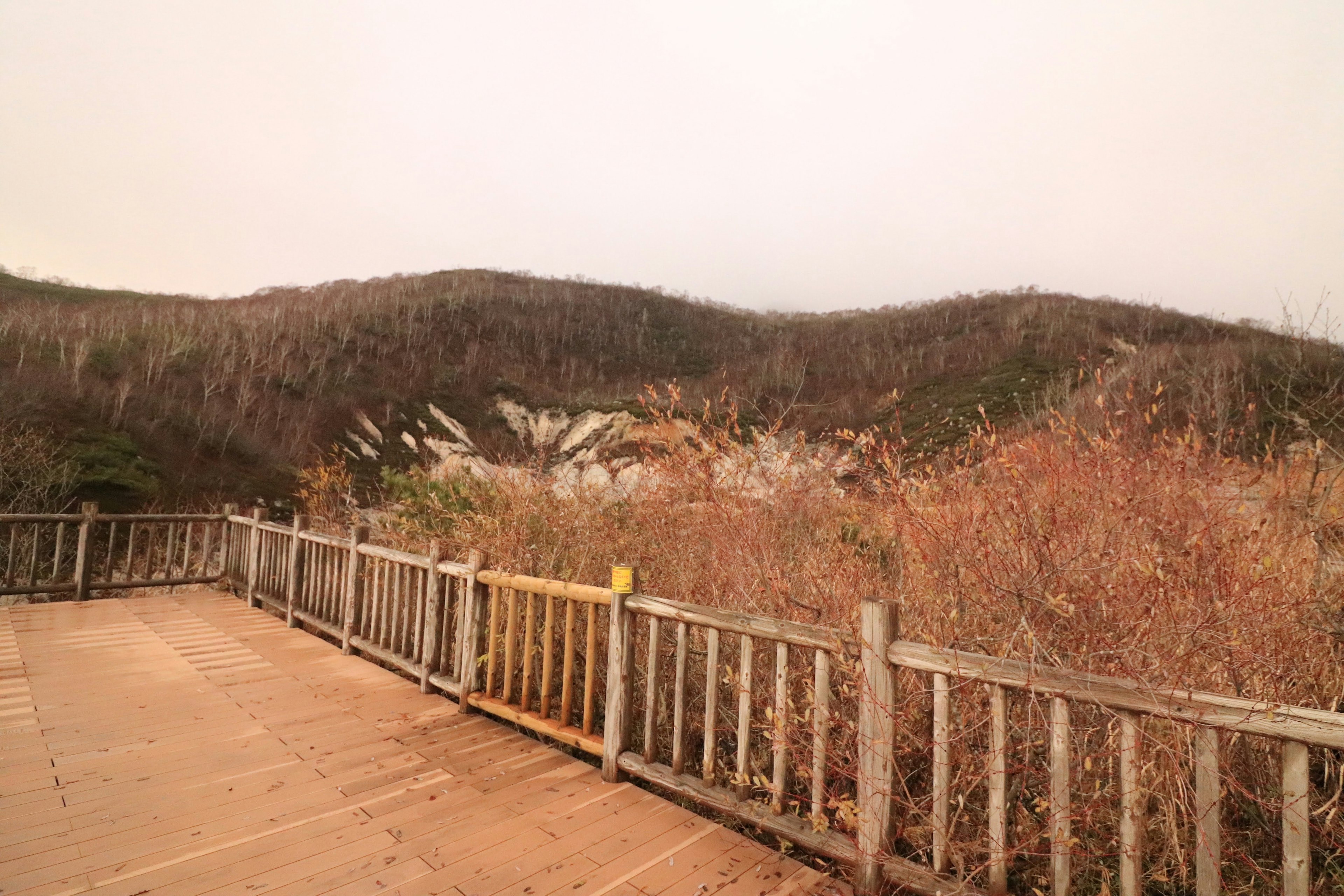 Vue panoramique des montagnes avec une clôture en bois et de l'herbe sèche