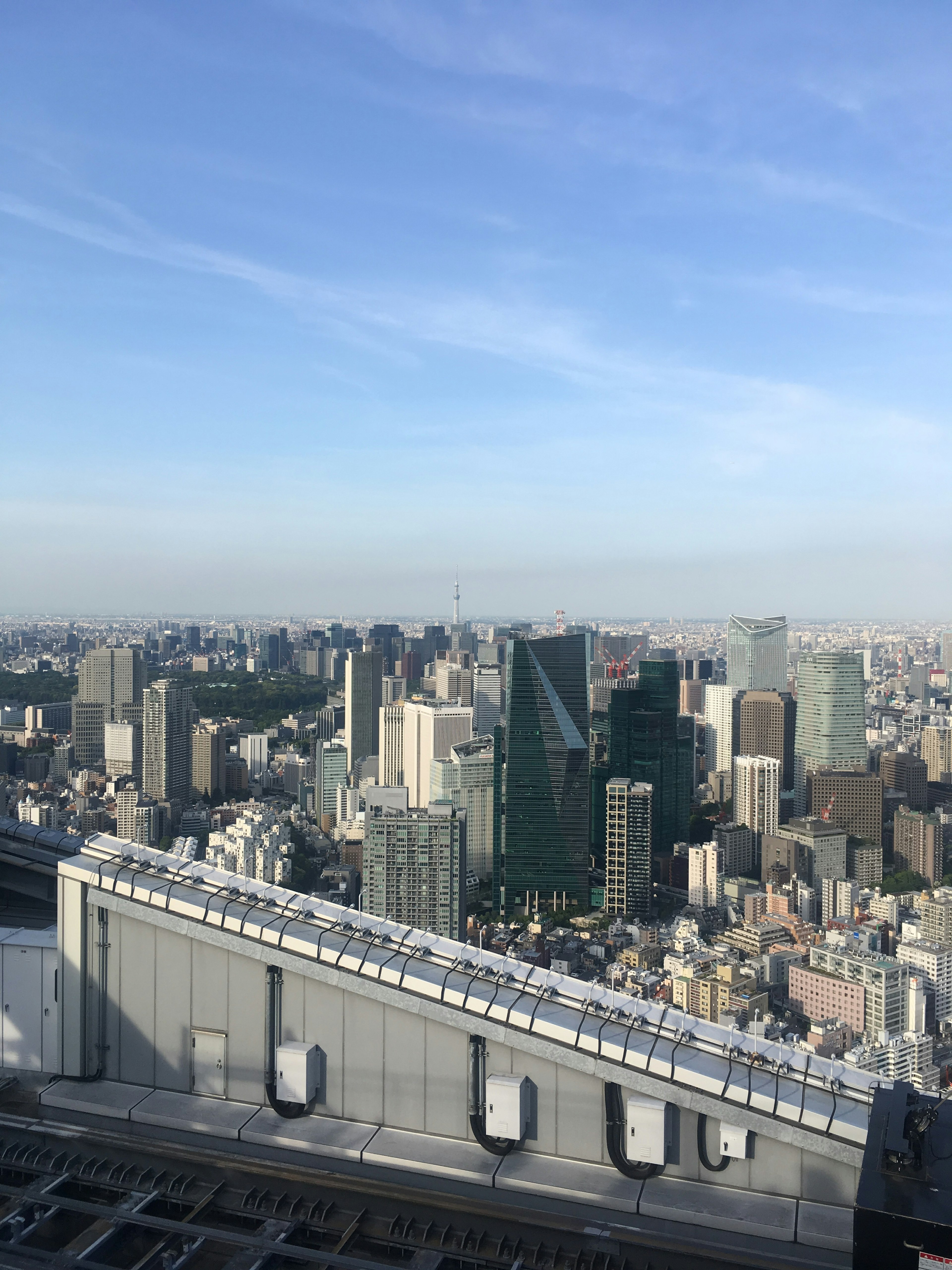 View of Tokyo skyline from a rooftop featuring skyscrapers and clear blue sky