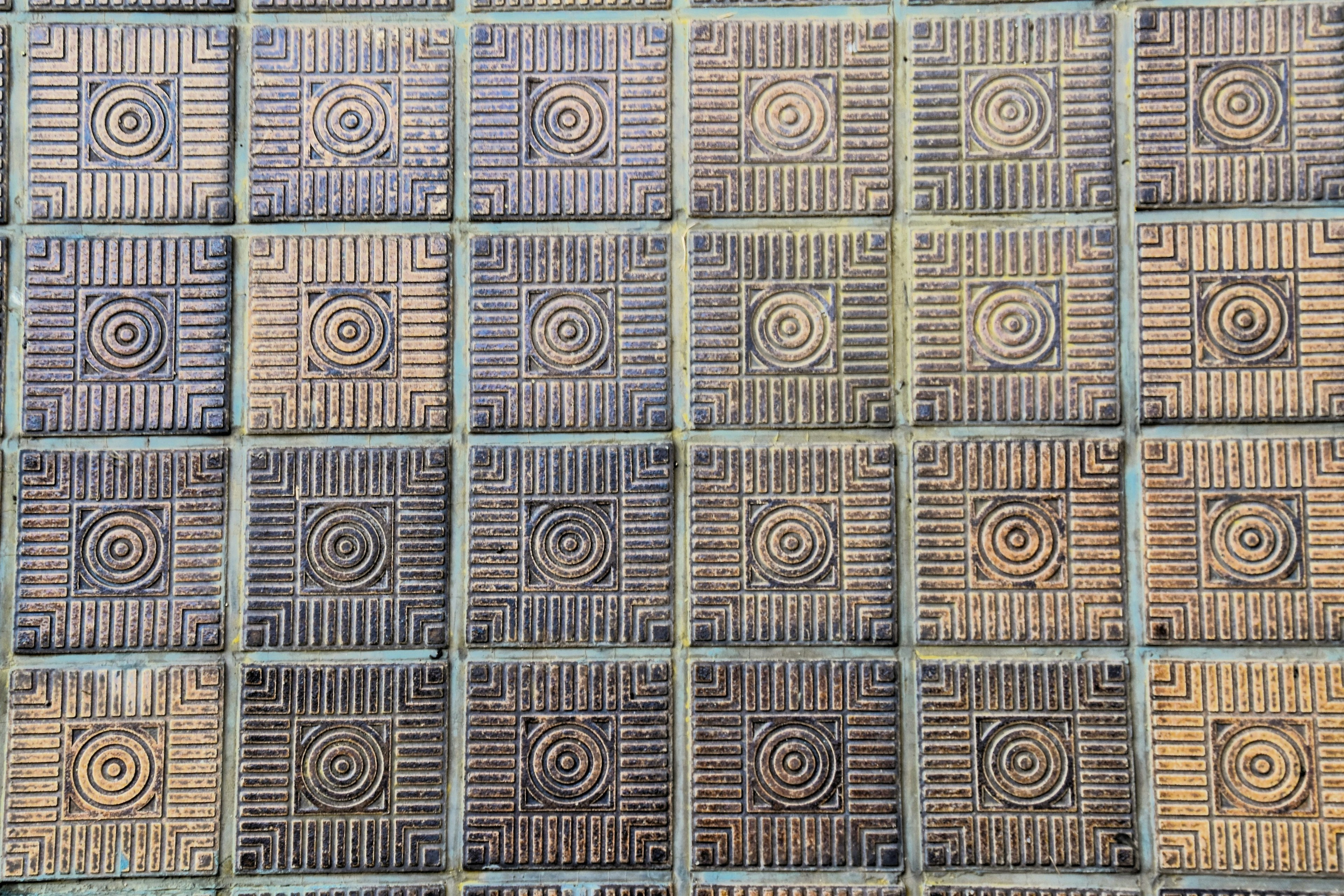 Image présentant un motif de carreaux texturés avec des cercles concentriques