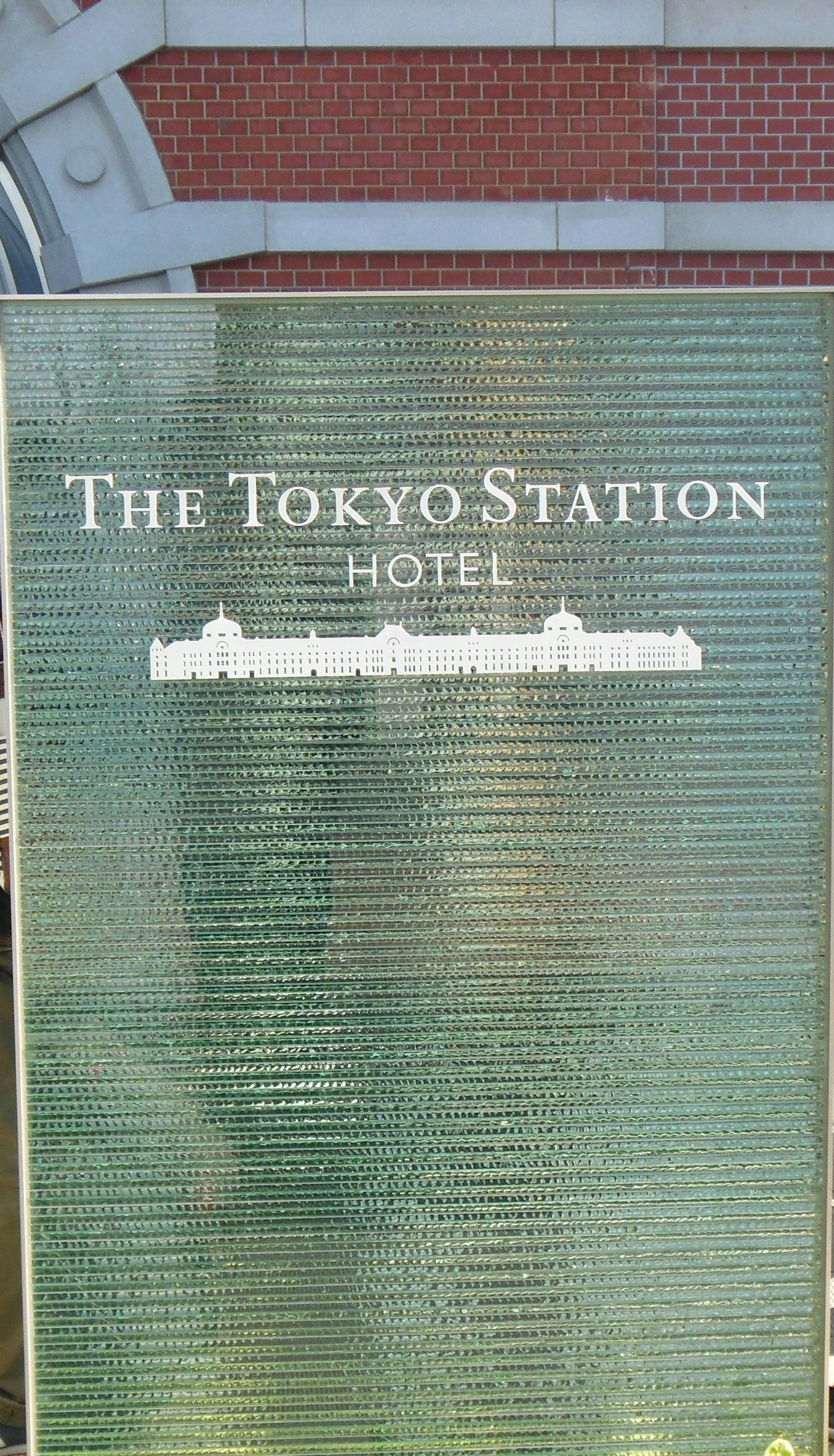 Schild für das Tokyo Station Hotel auf grünem Hintergrund mit weißen Buchstaben