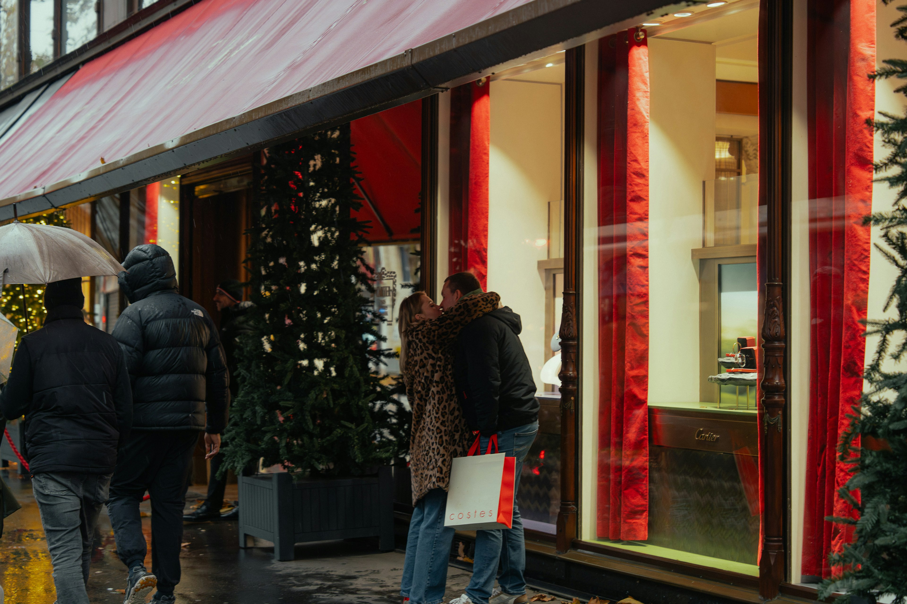 Group of people gathered in front of a store with red curtains