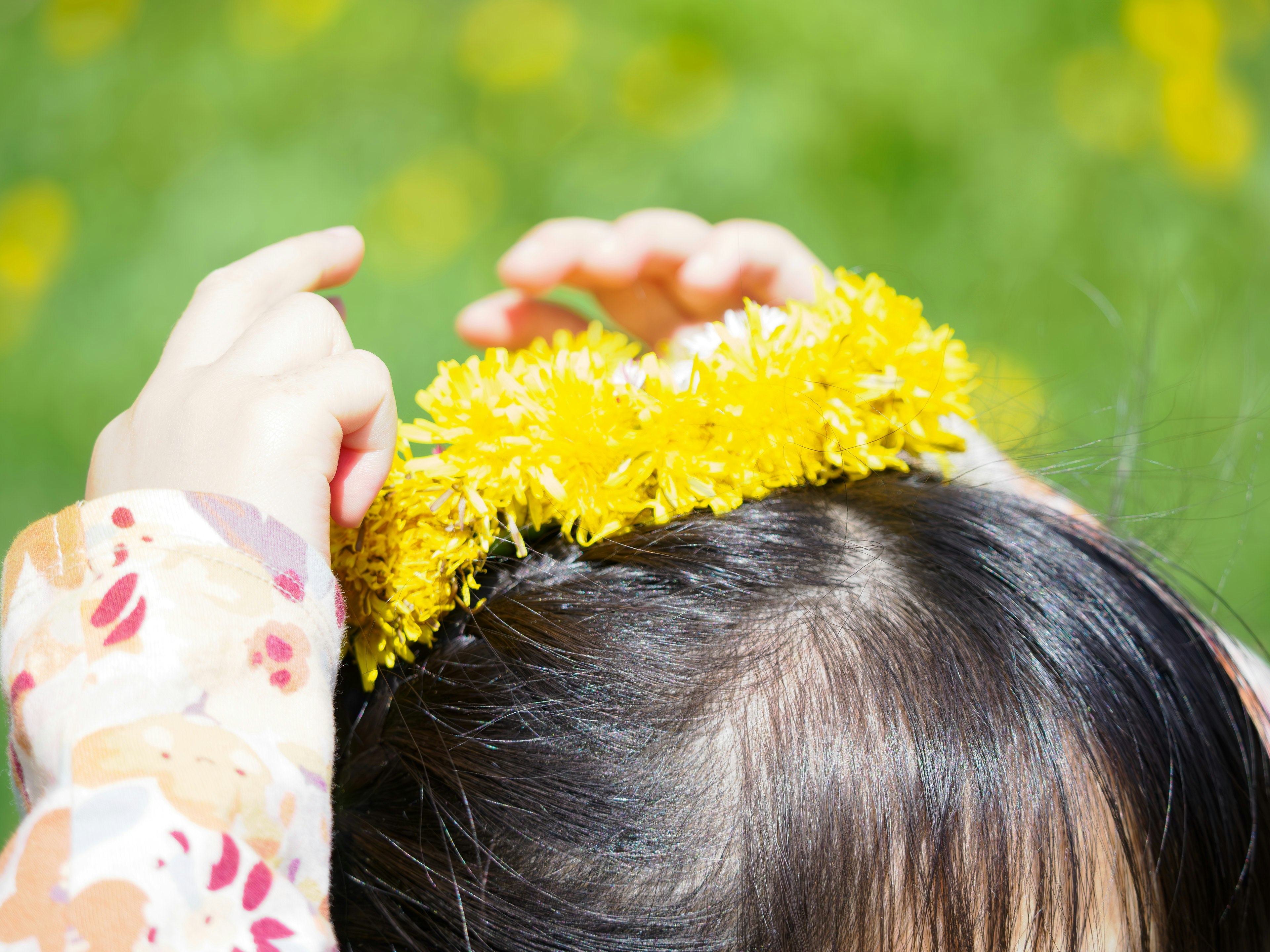 Child making a crown from yellow flowers