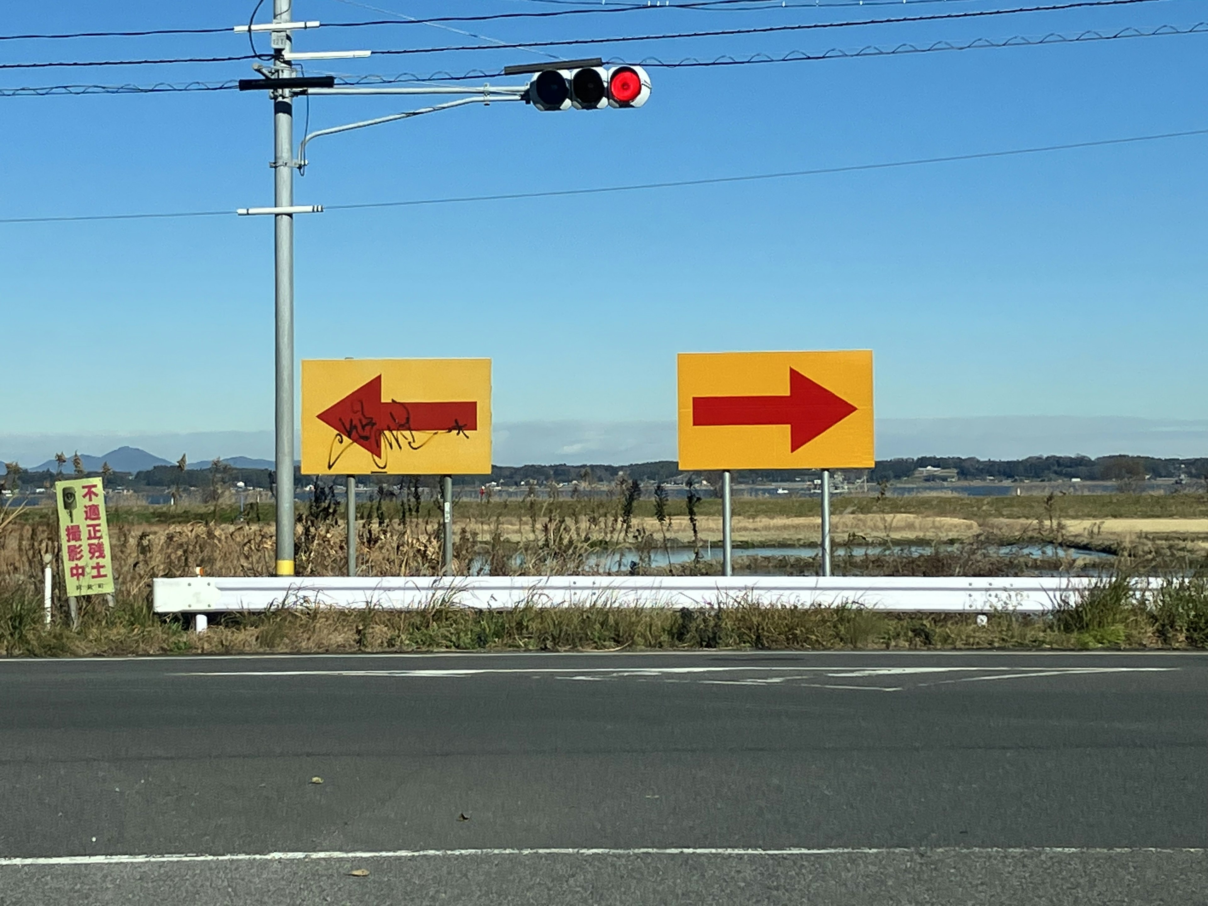 Verkehrsschilder, die nach links und rechts zeigen, mit einem roten Signal