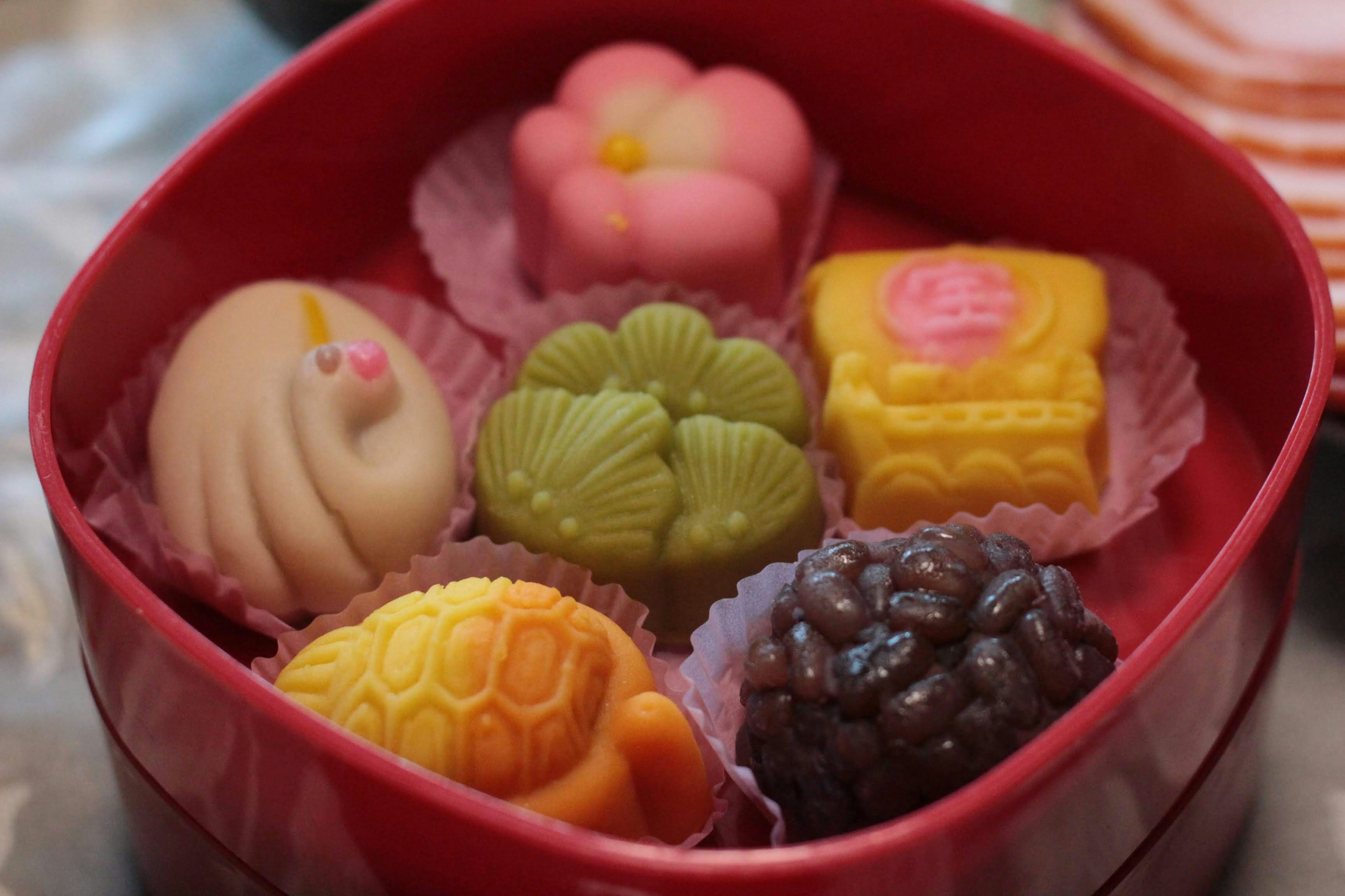 Sweets japonais colorés disposés dans une boîte rouge