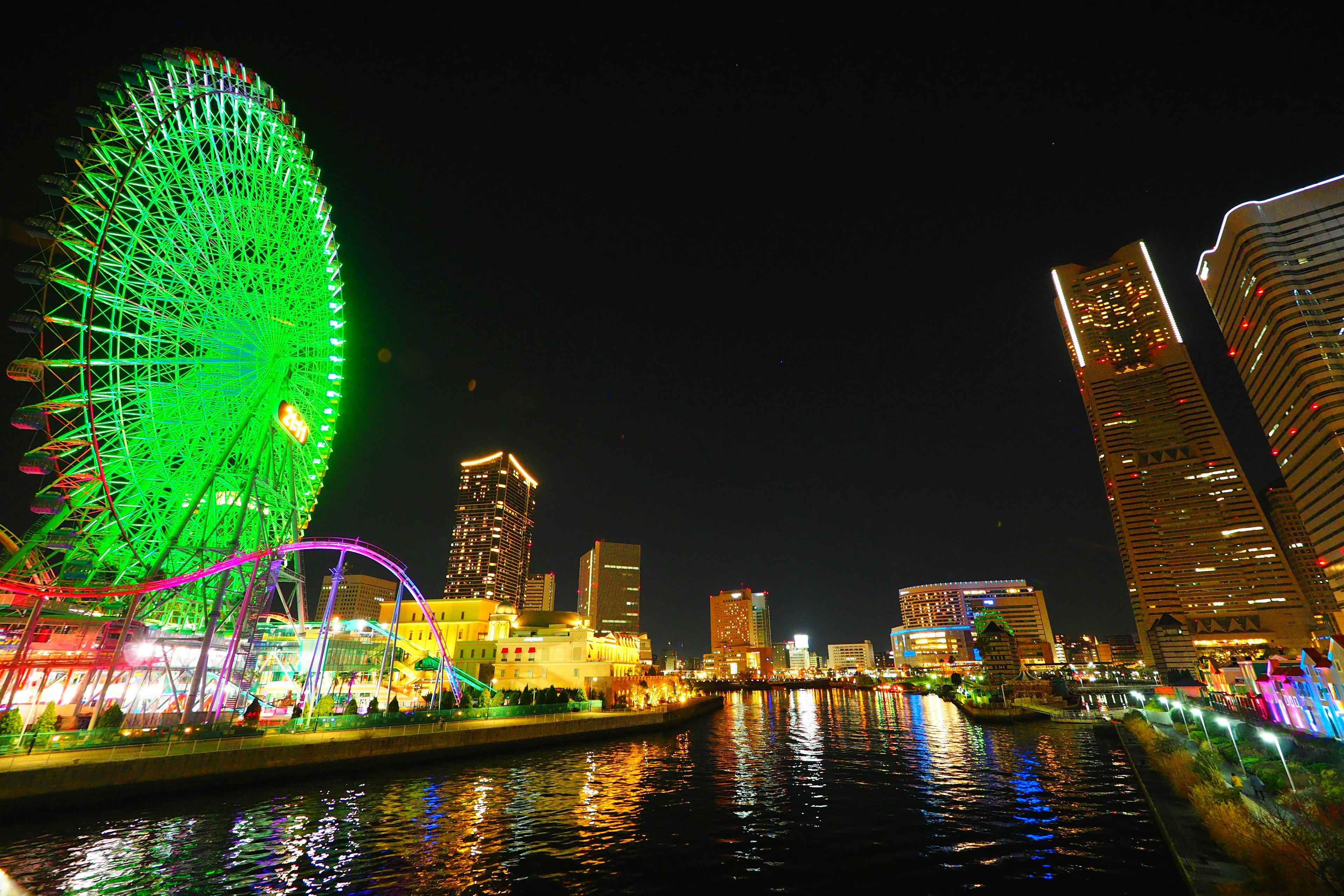 Vue nocturne magnifique de la grande roue et des gratte-ciels de Yokohama