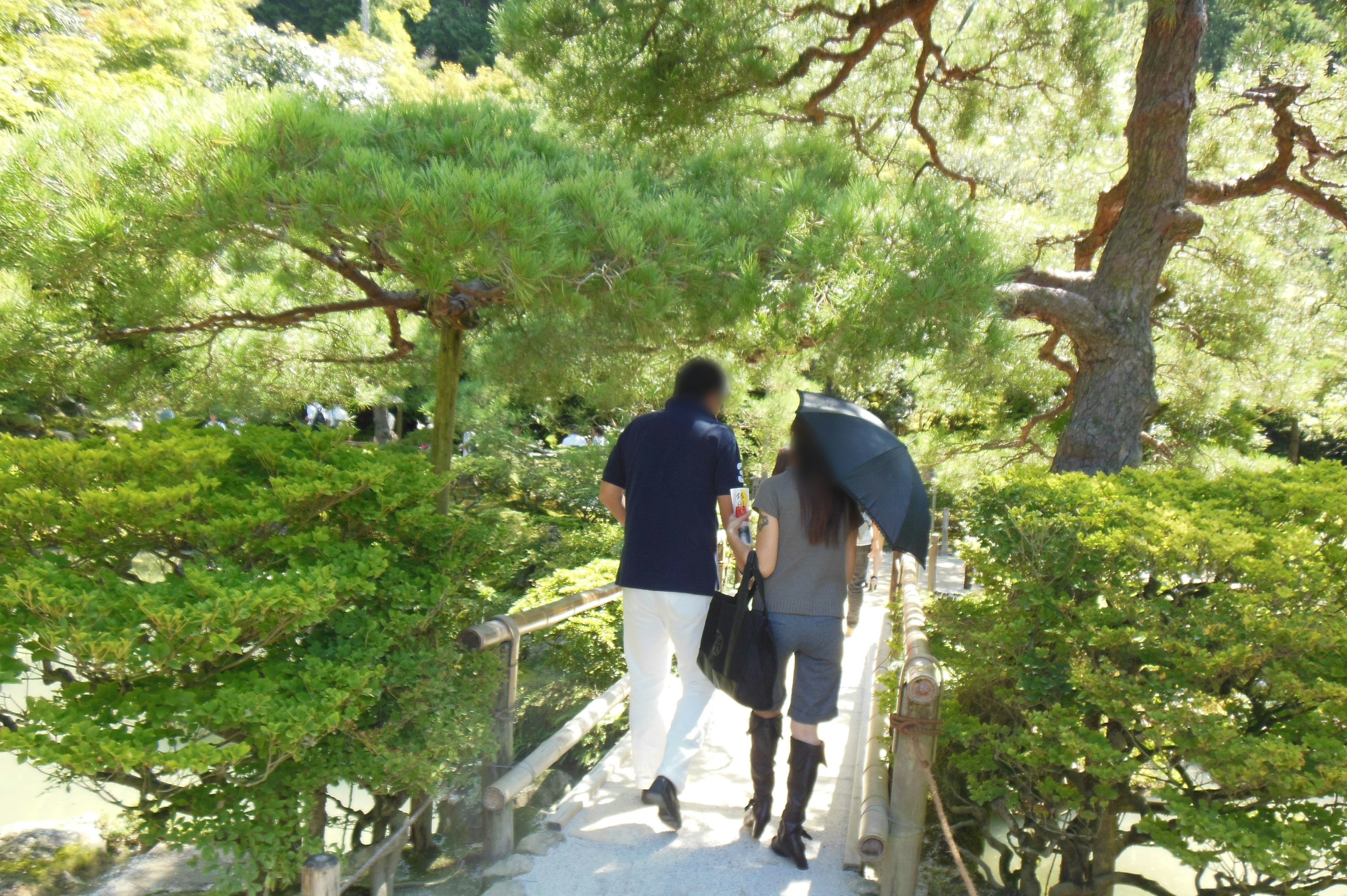 Dos personas caminando en un jardín exuberante con un paraguas