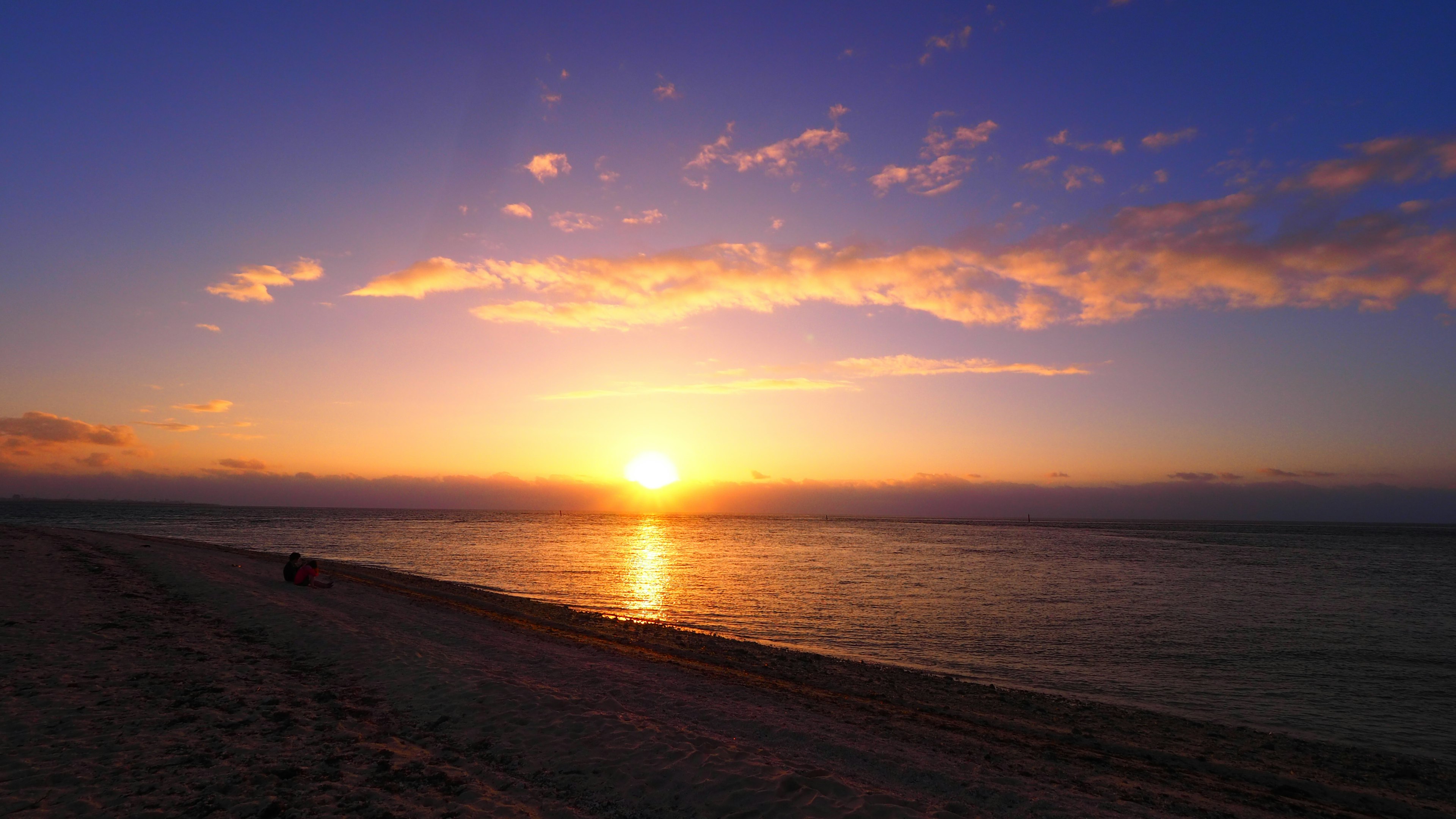 Schöner Sonnenuntergang über dem Ozean mit blauem Himmel und Wolken