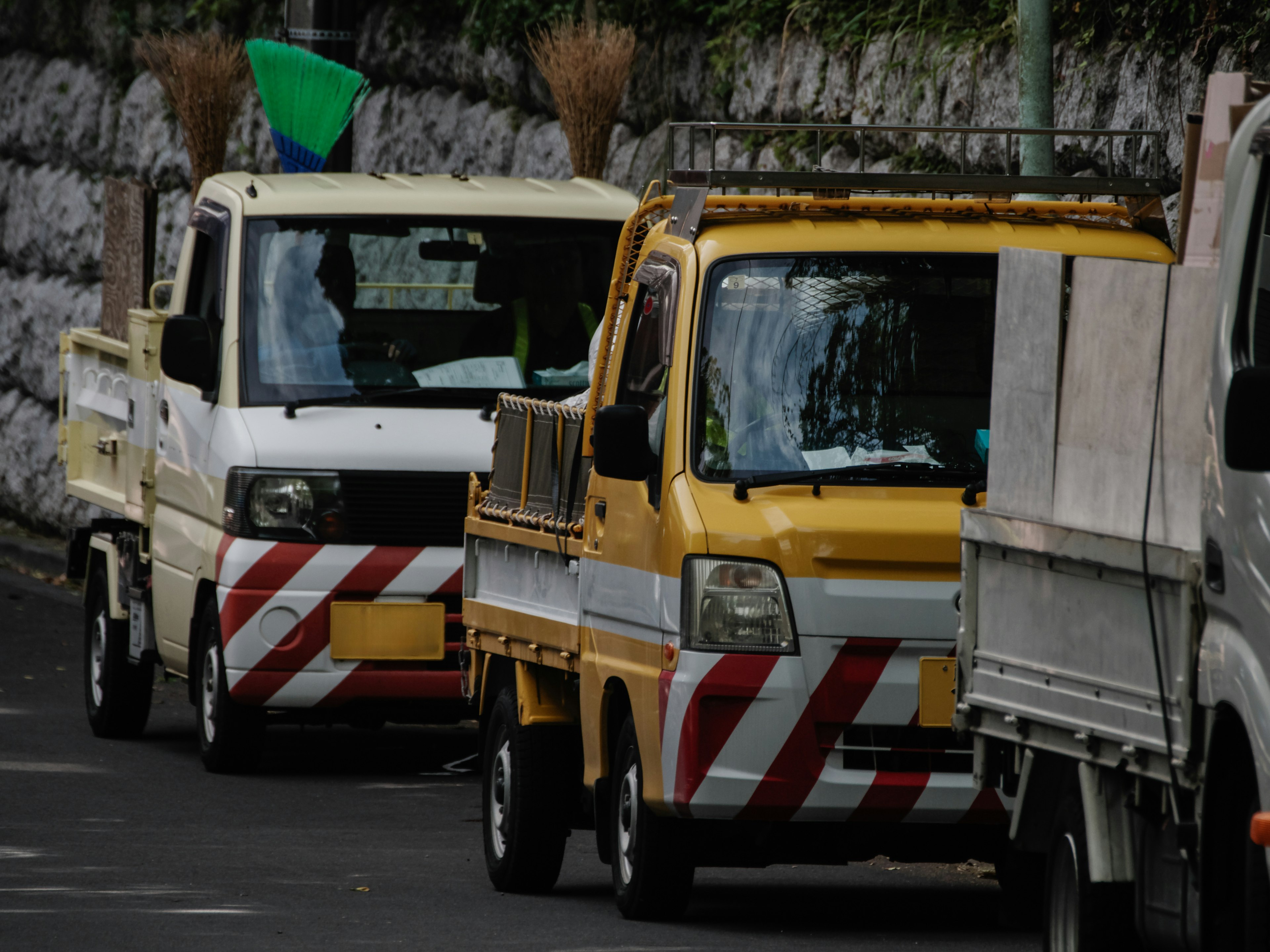 A row of yellow and white trucks on a city street