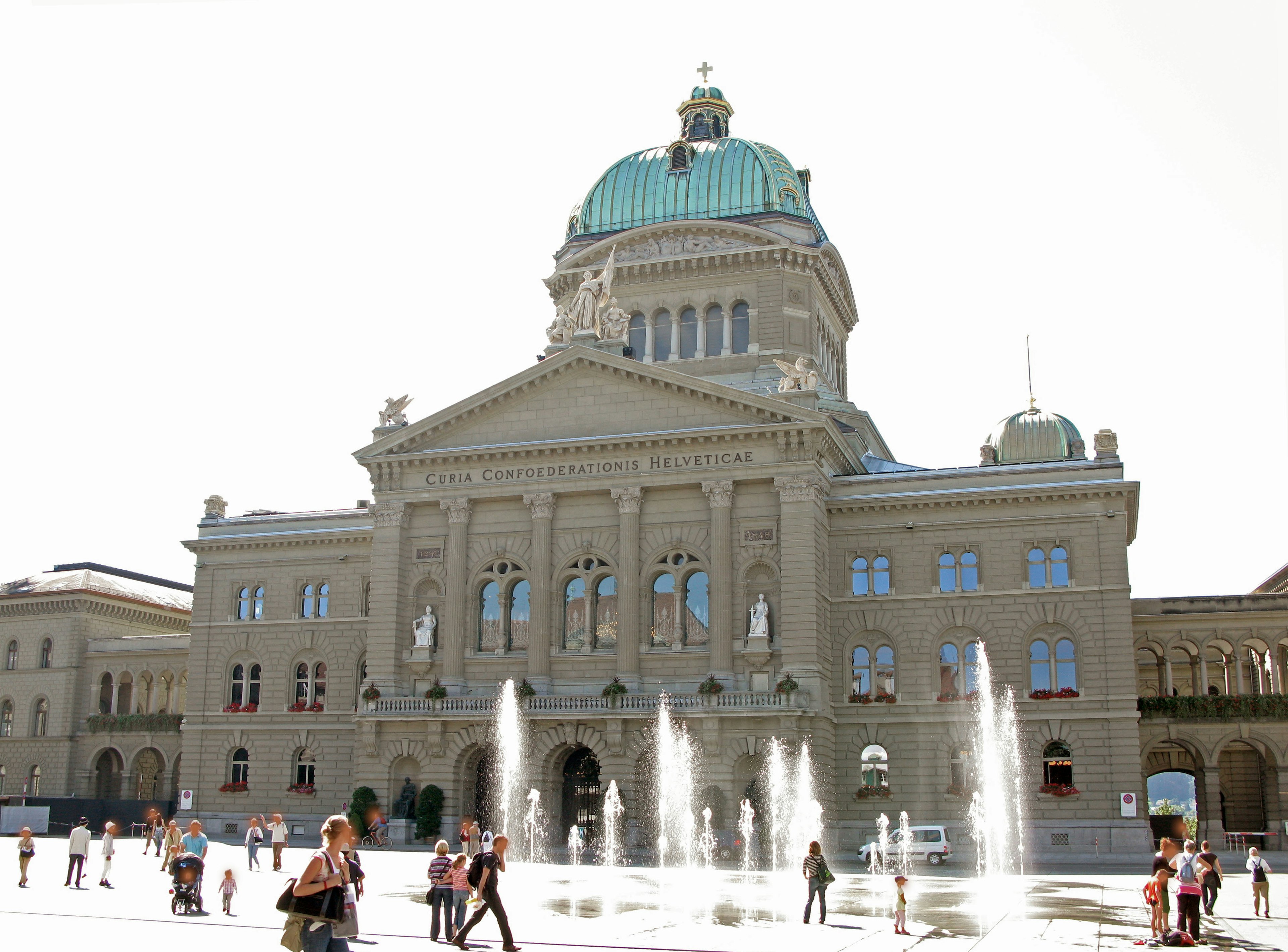 Schweizer Bundeshaus mit grüner Kuppel umgeben von Menschen und Brunnen