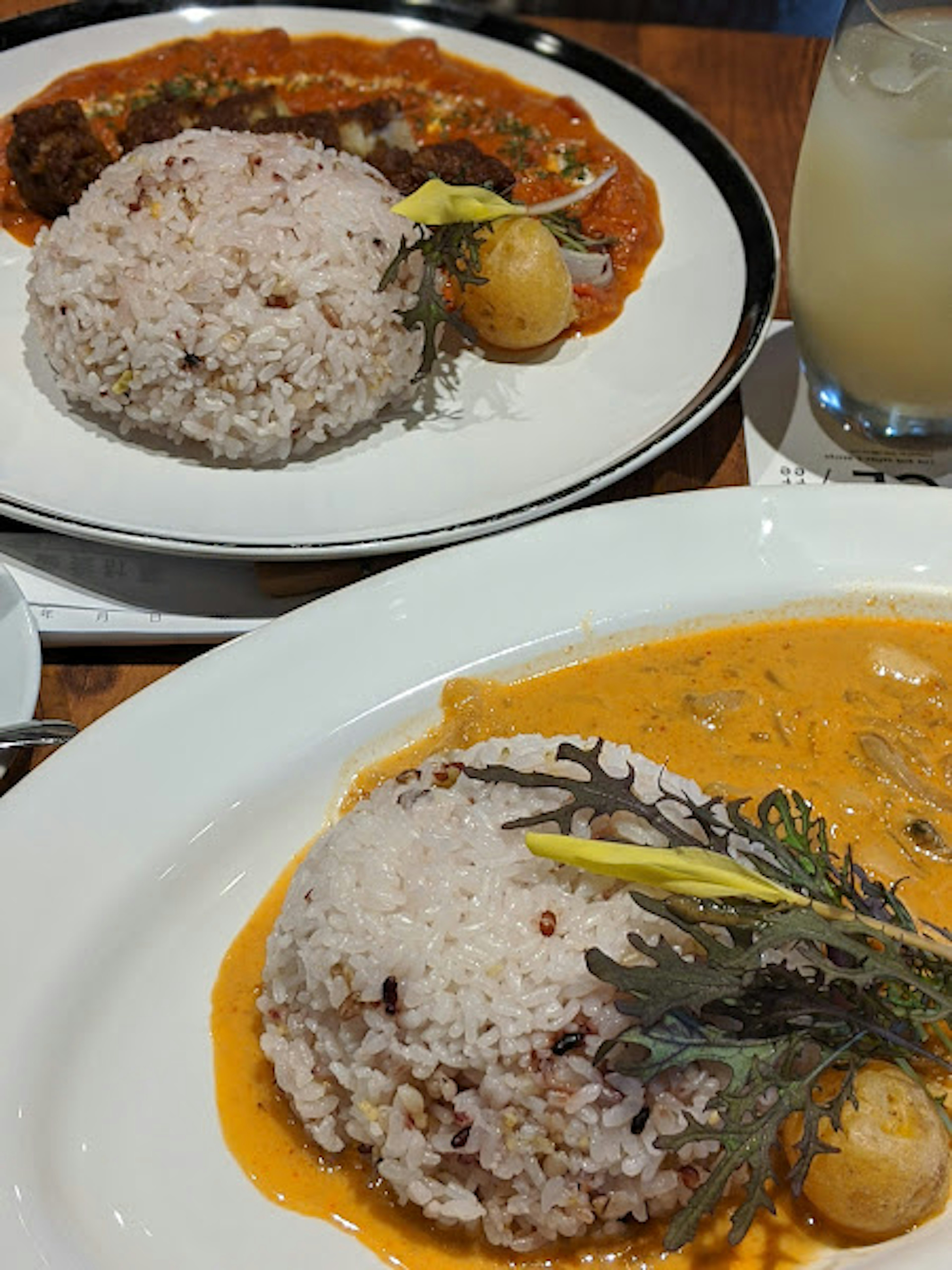 Two plates featuring brown rice and creamy curry sauce