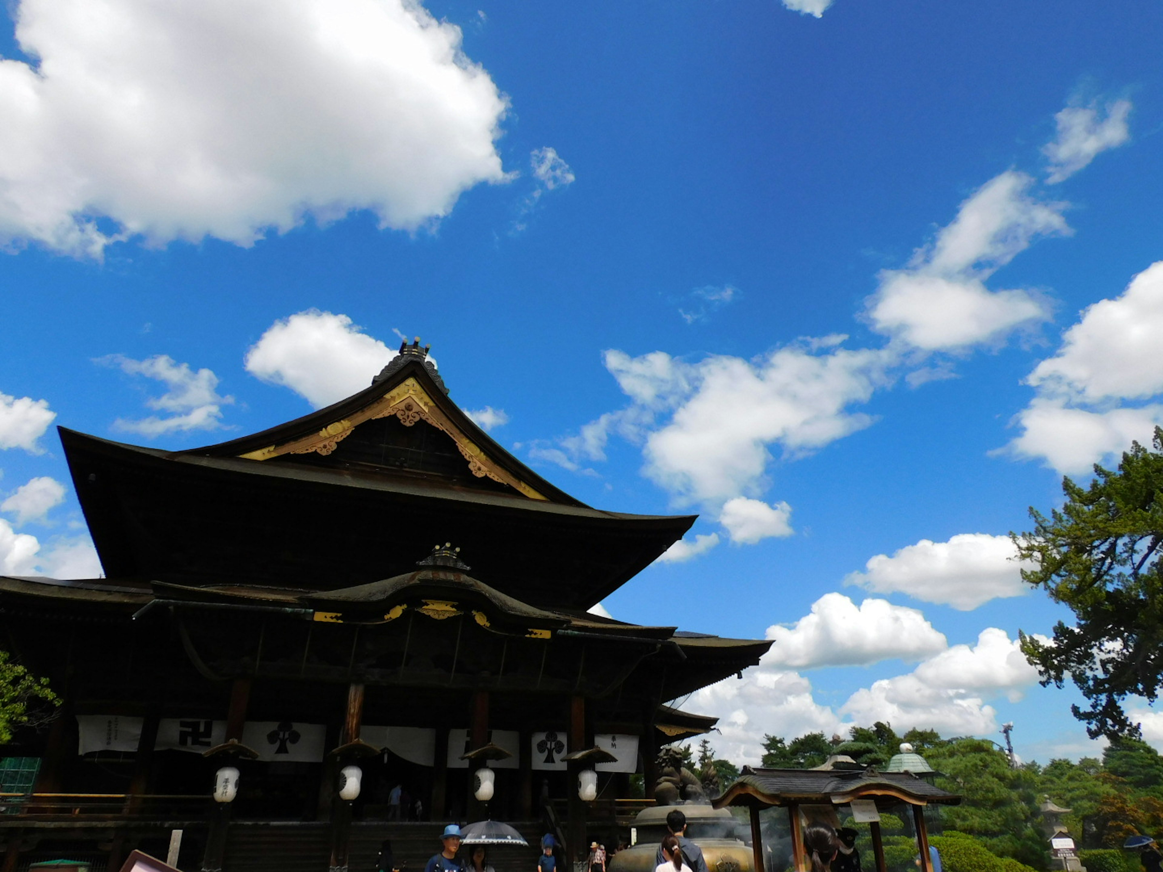 美丽的日本寺庙屋顶在蓝天和云朵下，有人