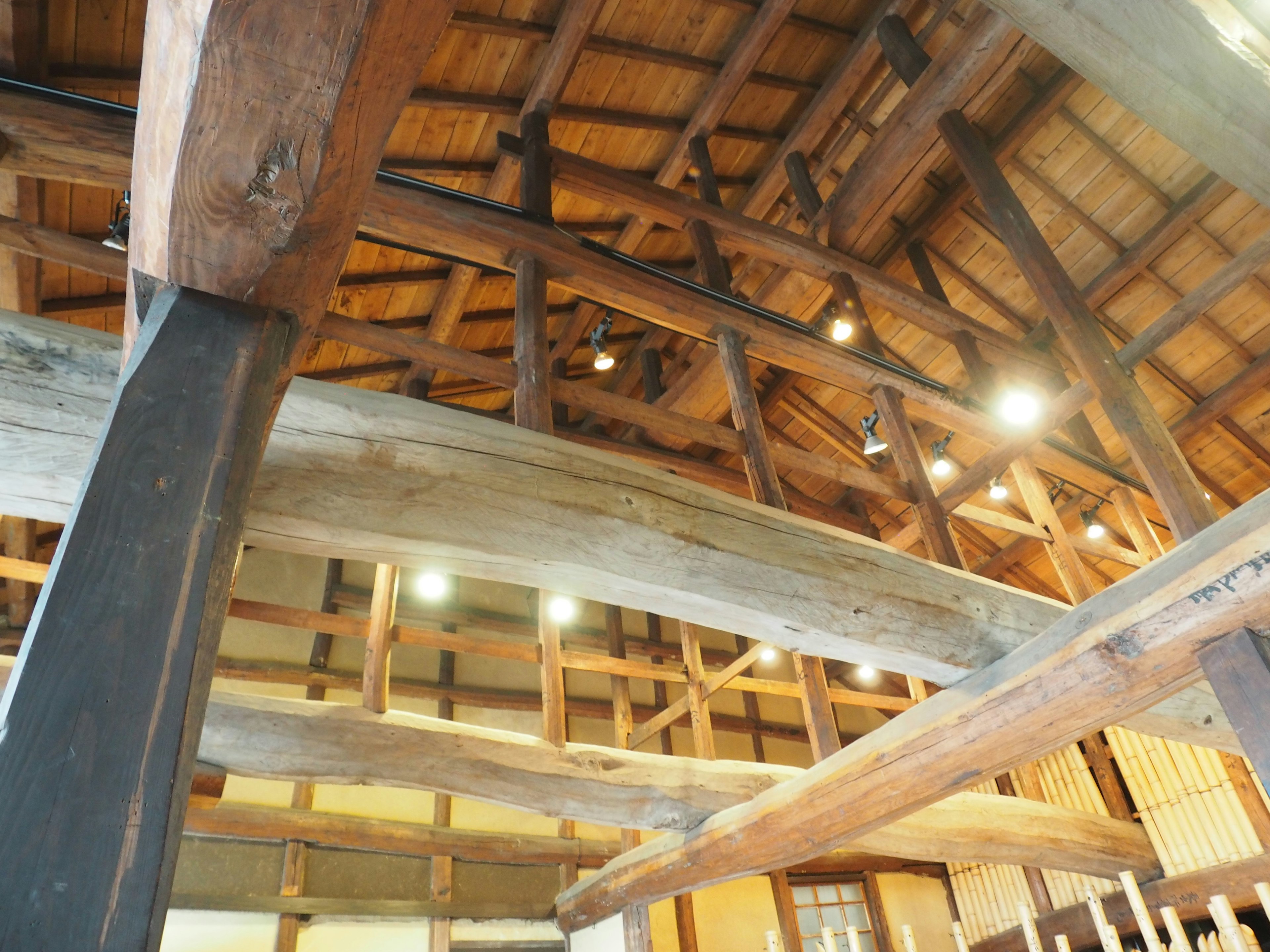 Vue intérieure d'un bâtiment en bois traditionnel montrant la structure du toit