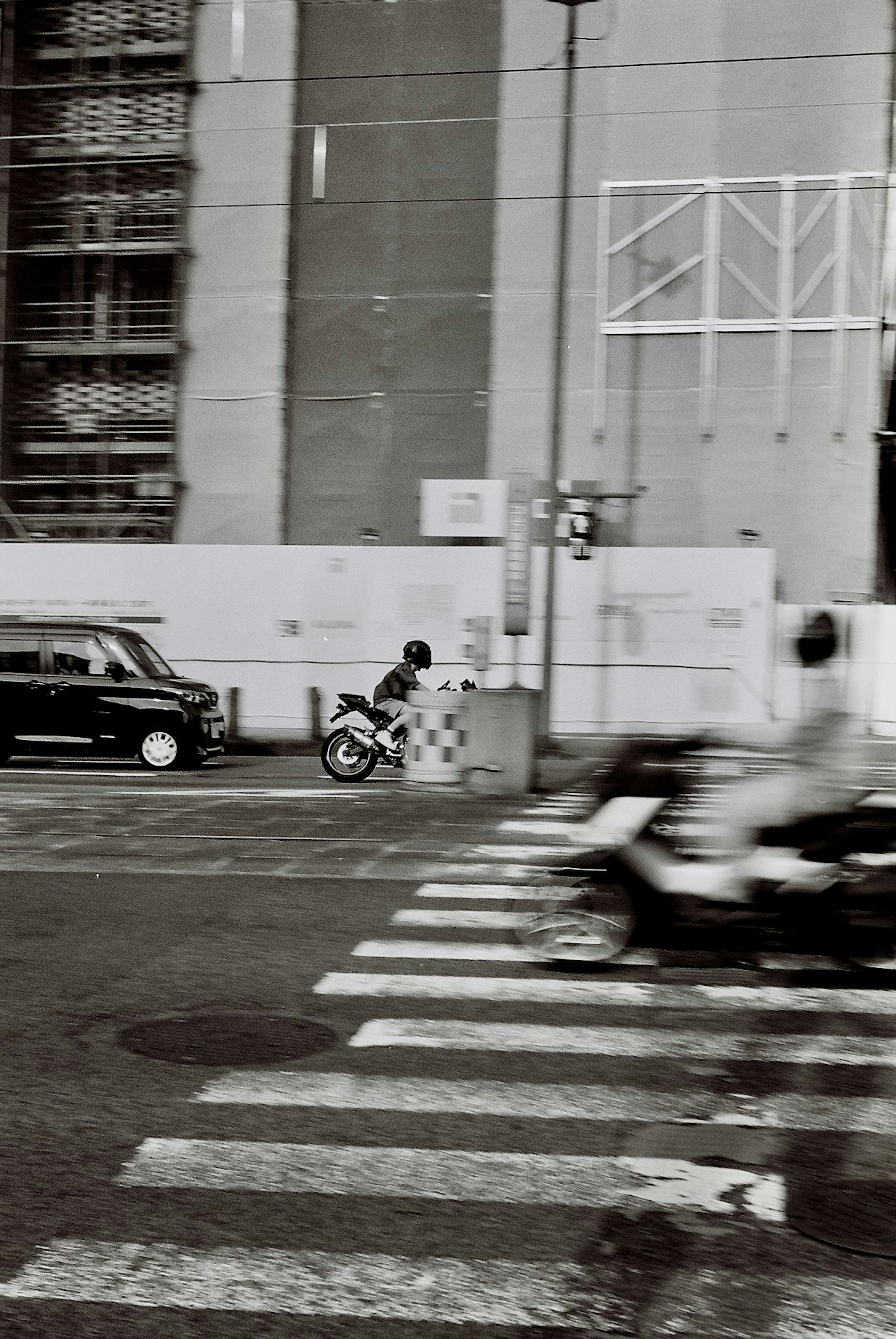 Scène urbaine en noir et blanc avec circulation de bicyclettes et de voitures