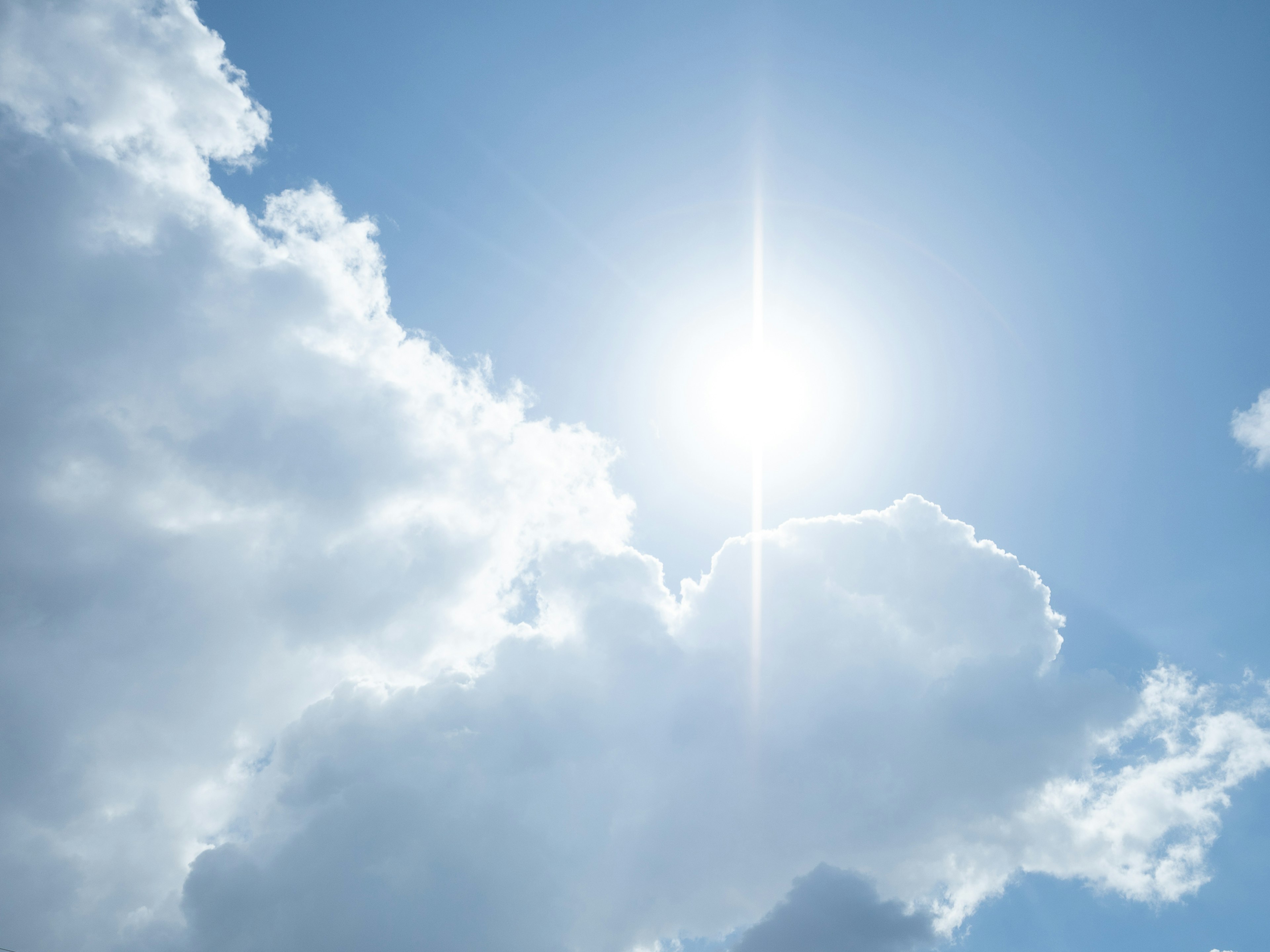 Awan putih di langit biru dengan sinar matahari yang cerah