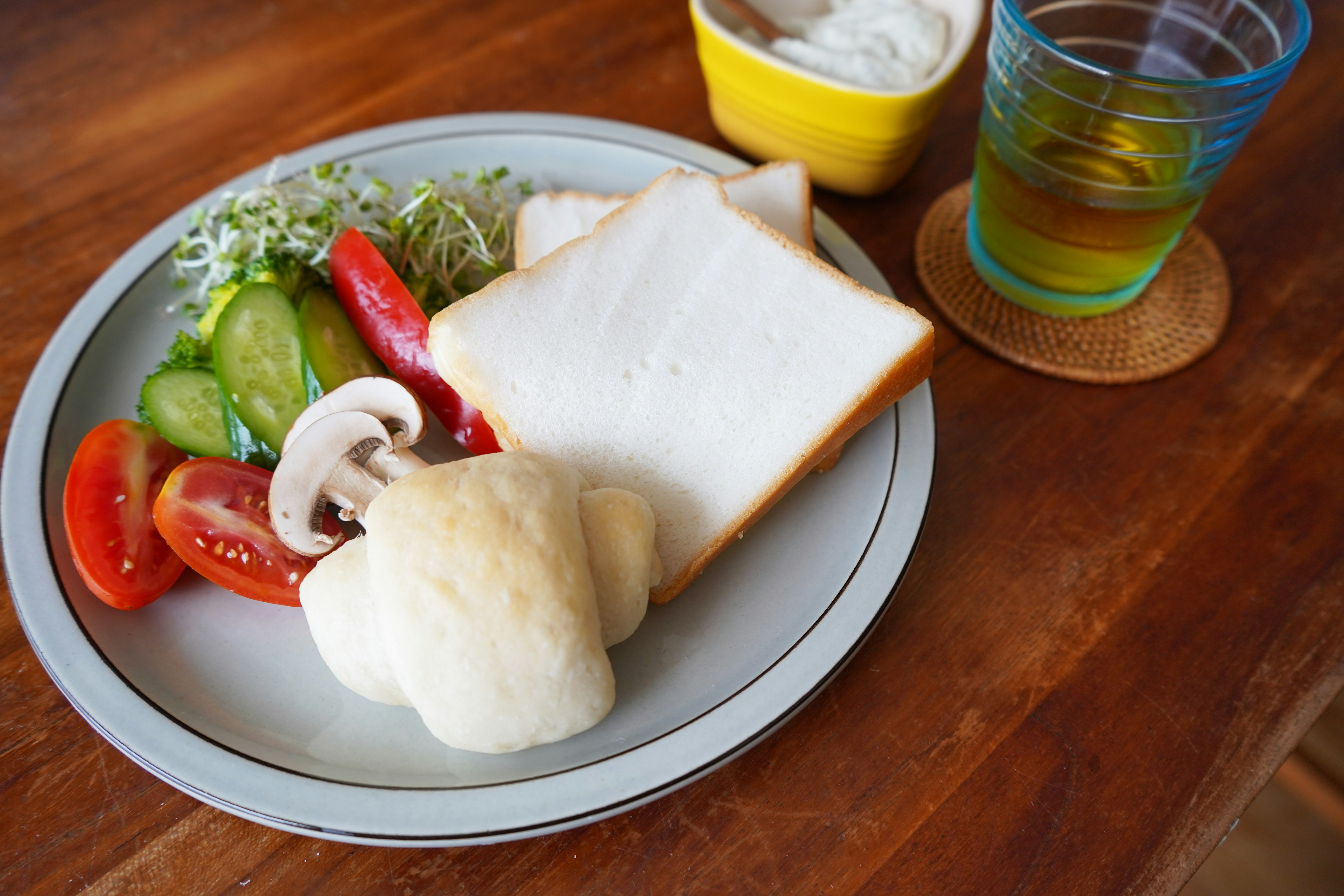 Piring salad dan roti termasuk tomat mentimun dan jamur