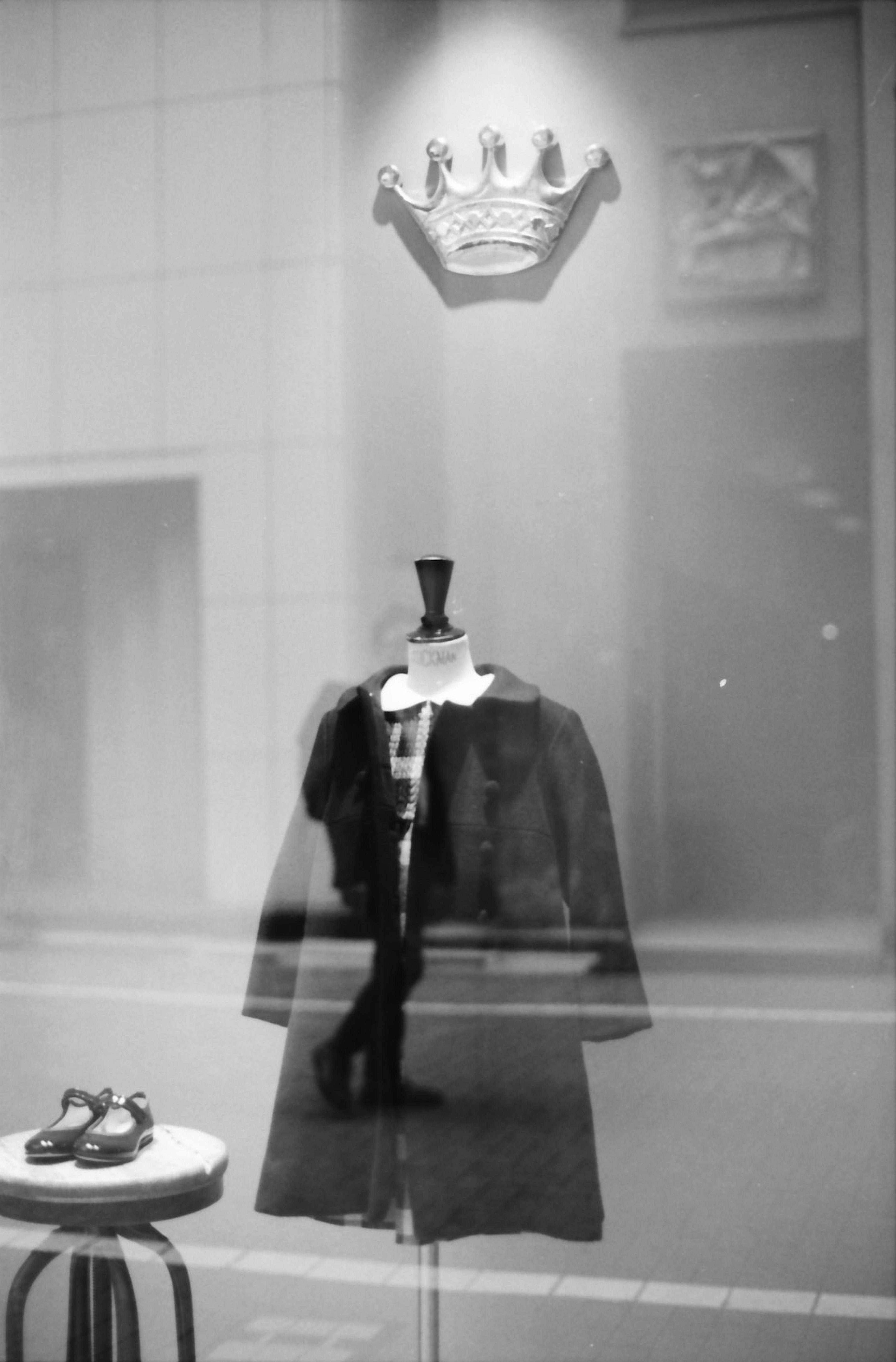 Black coat on a mannequin with a crown decoration above