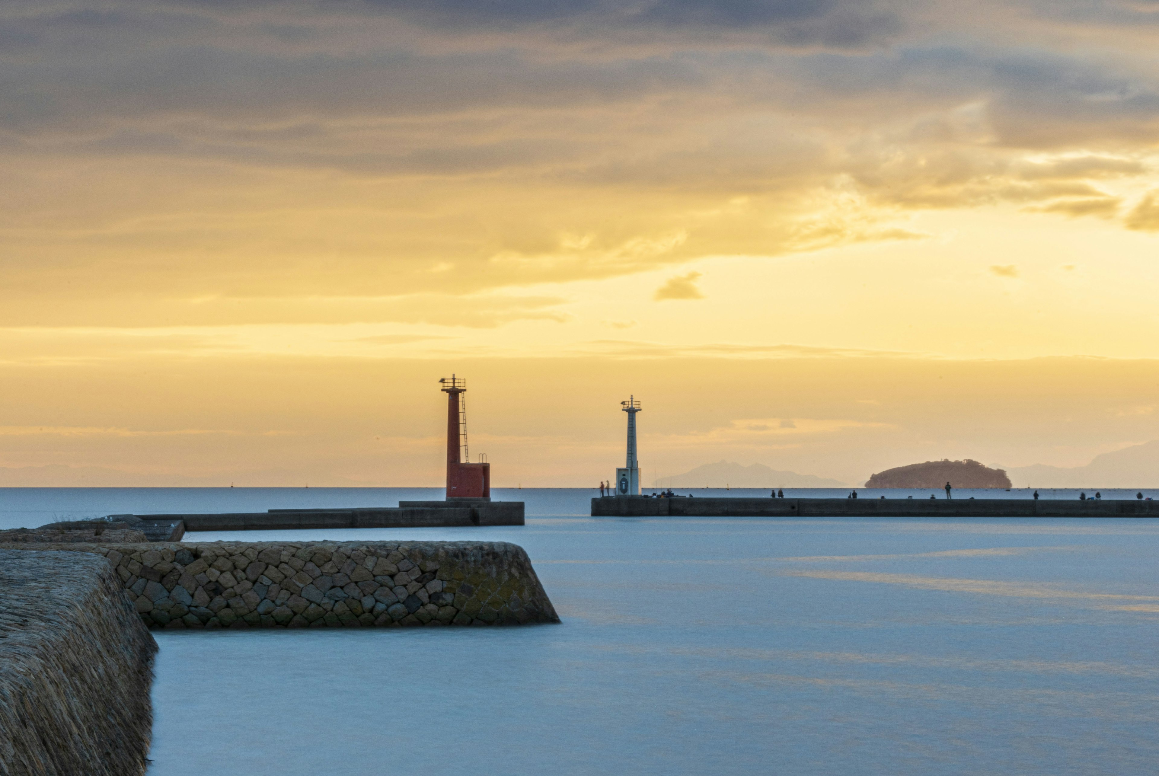 Scenic view of the sea with lighthouses and a sunset sky