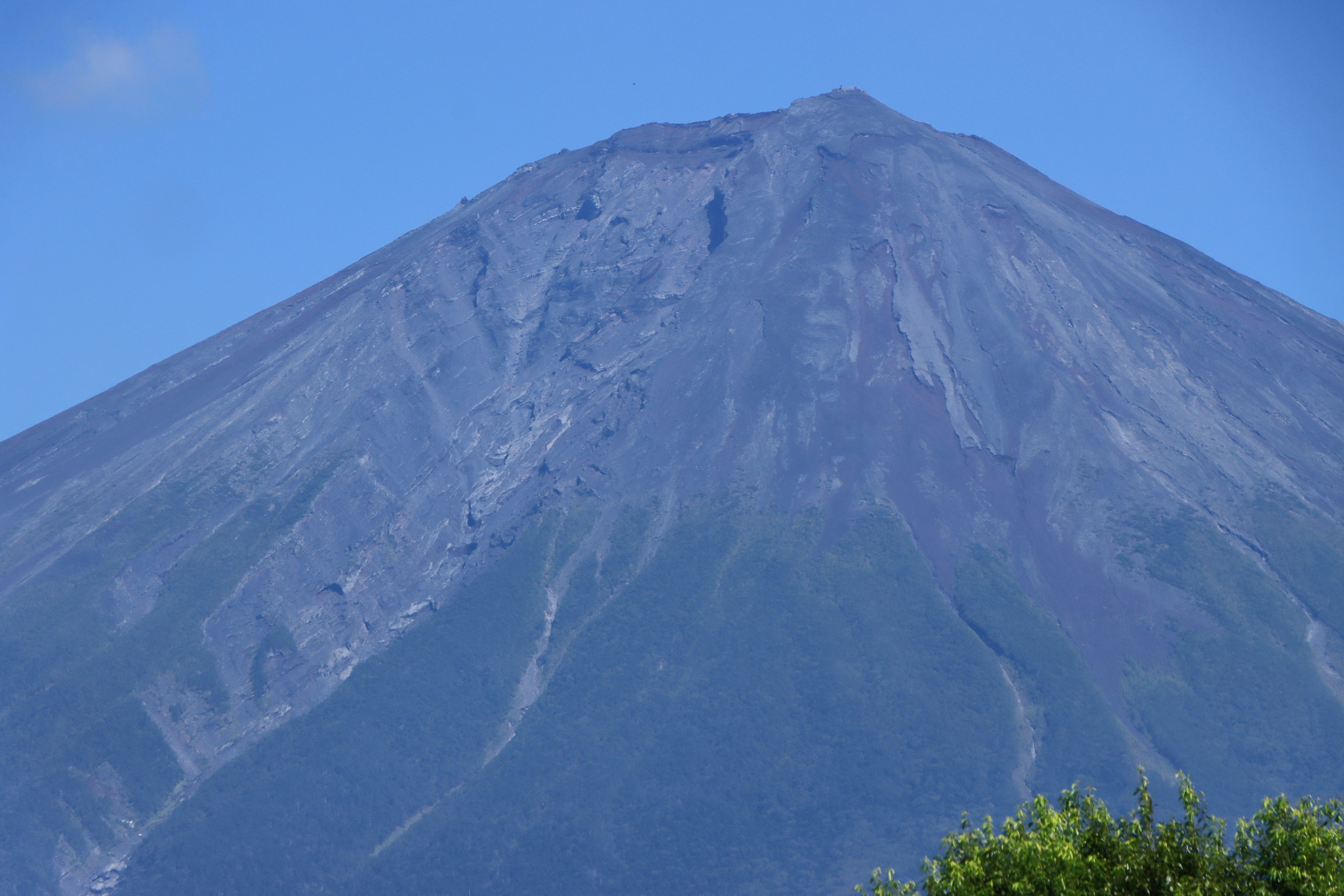 Un sommet volcanique s'élevant contre un ciel bleu