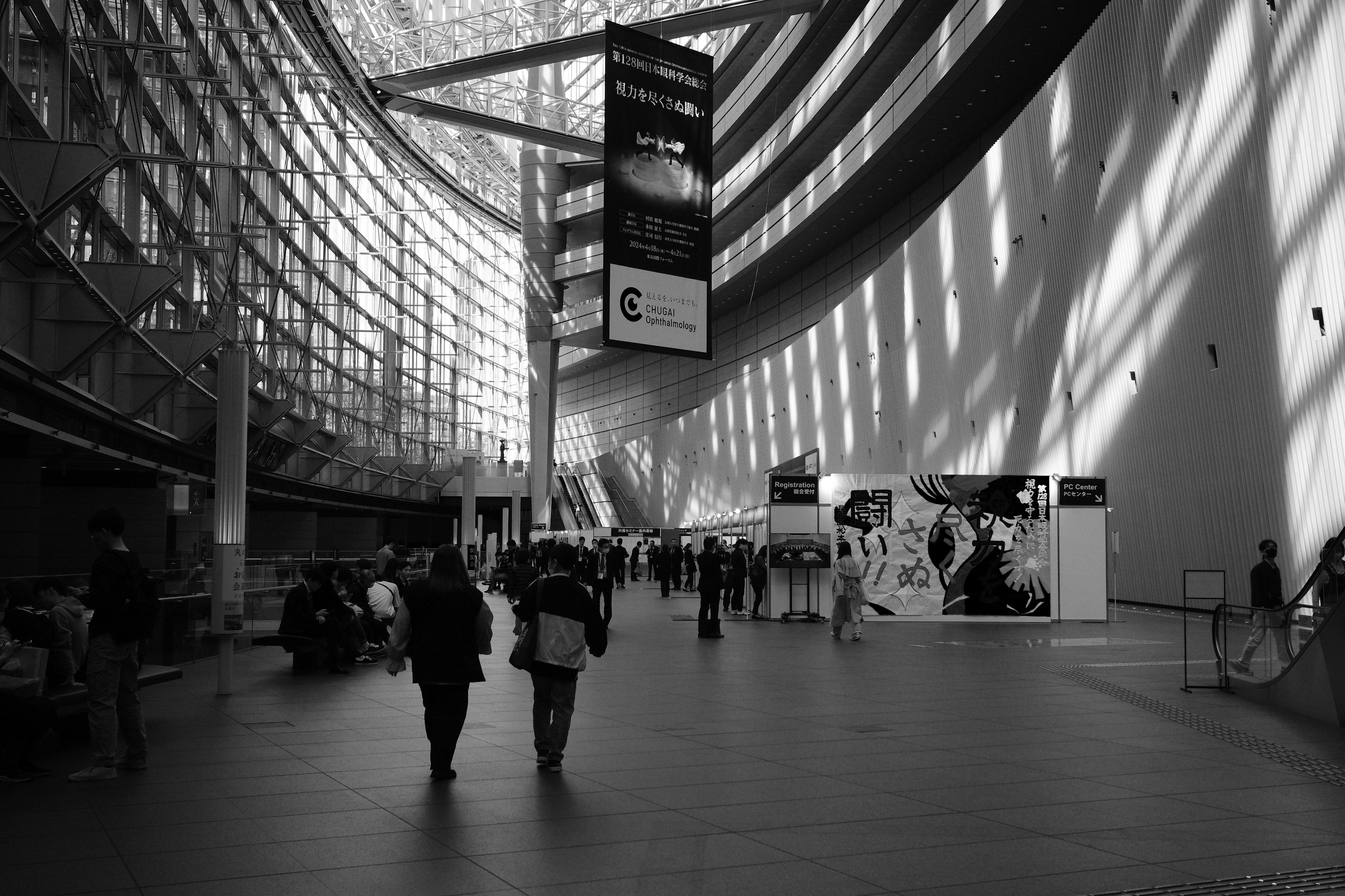 Interior de arquitectura moderna en blanco y negro con personas caminando