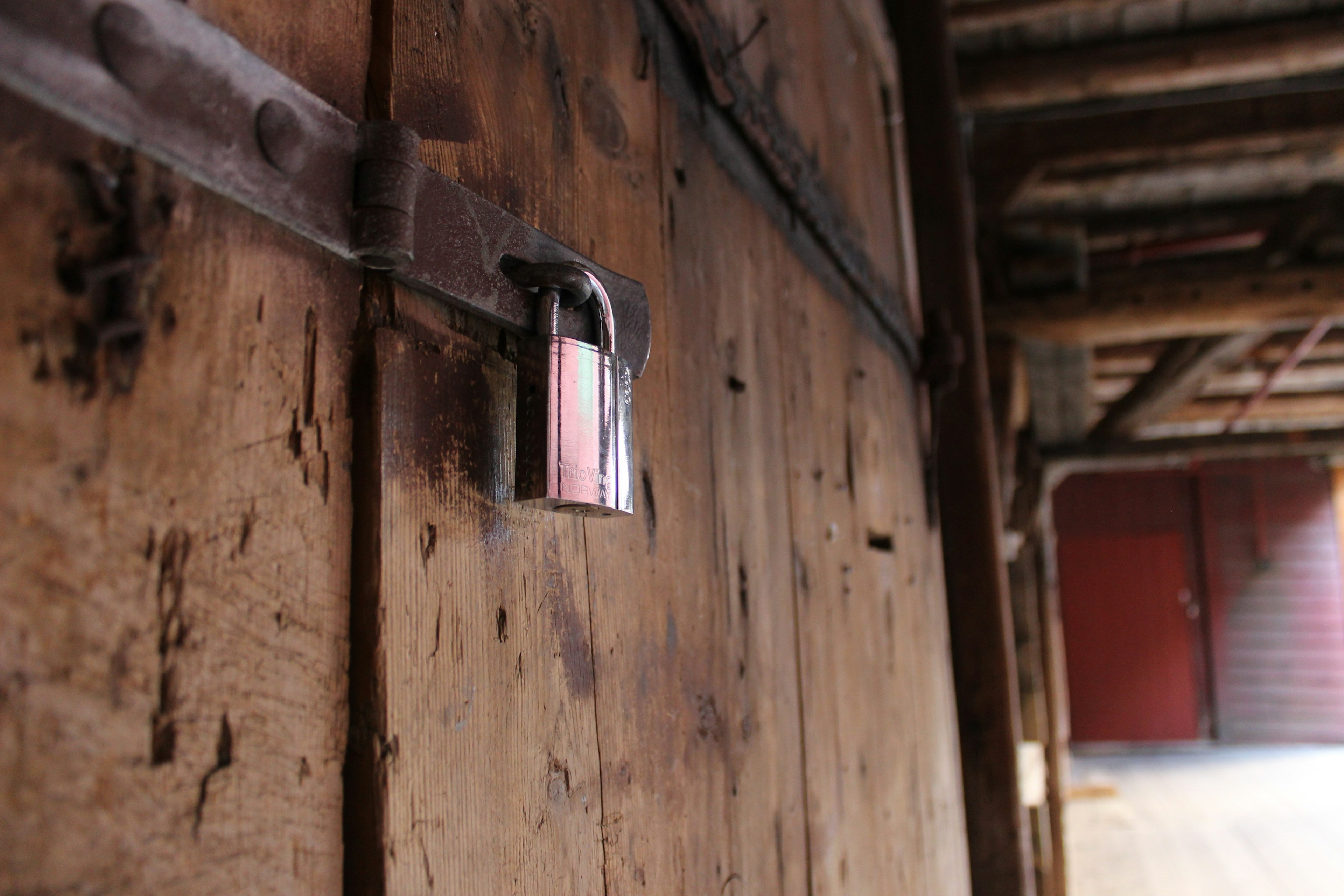 Close-up of a silver padlock on a wooden door