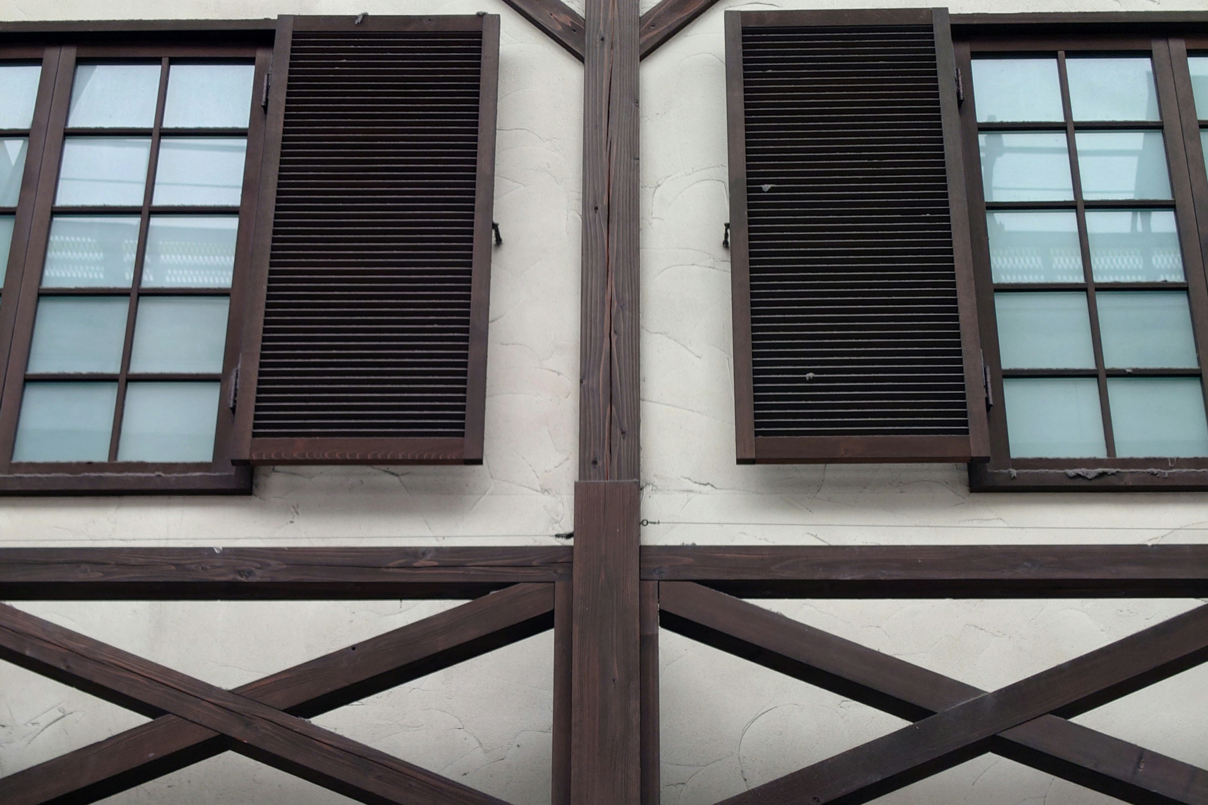 Symmetrical design of wooden shutters and windows on an old building