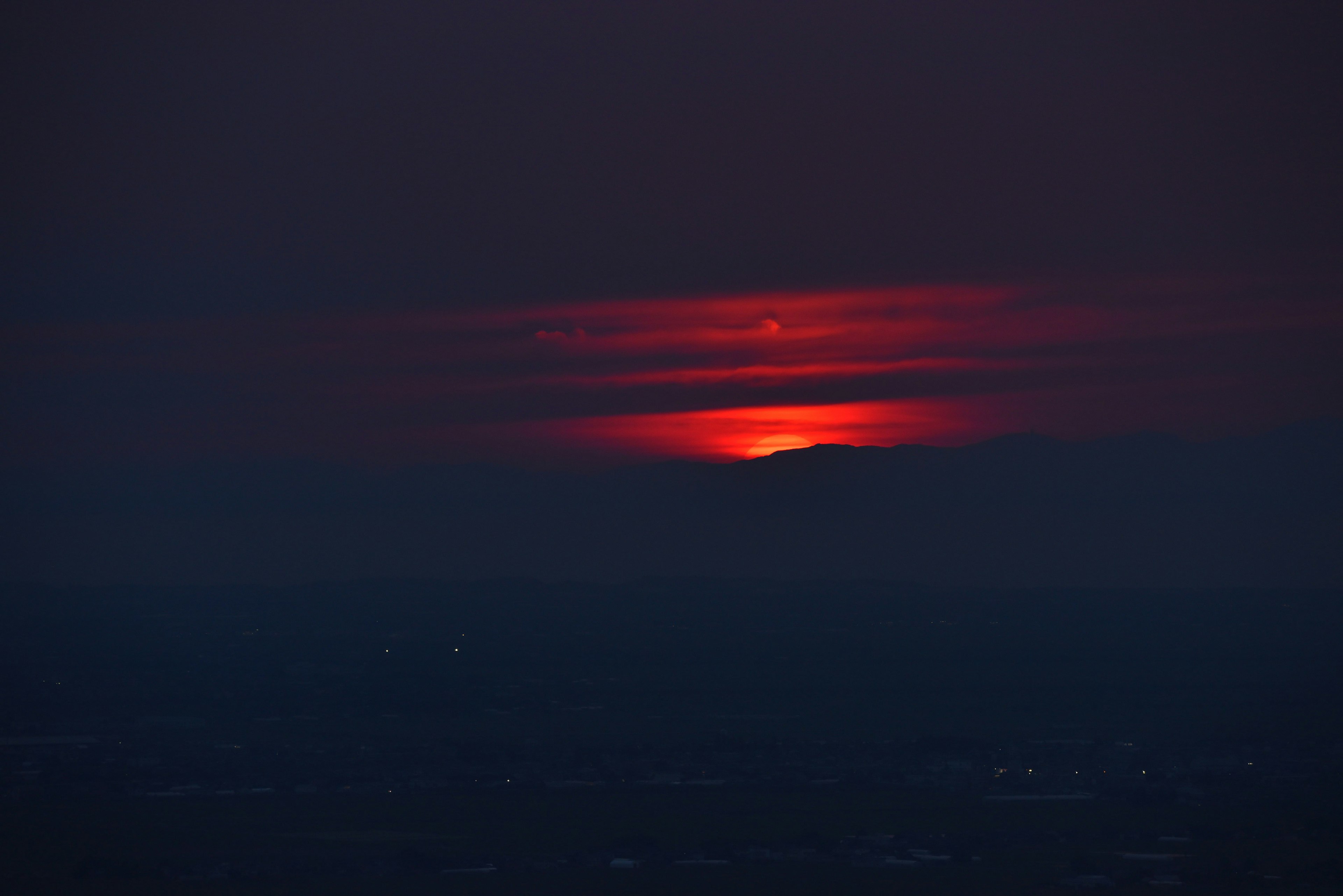 Roter Sonnenuntergang hinter den Bergen mit dunklem Himmel