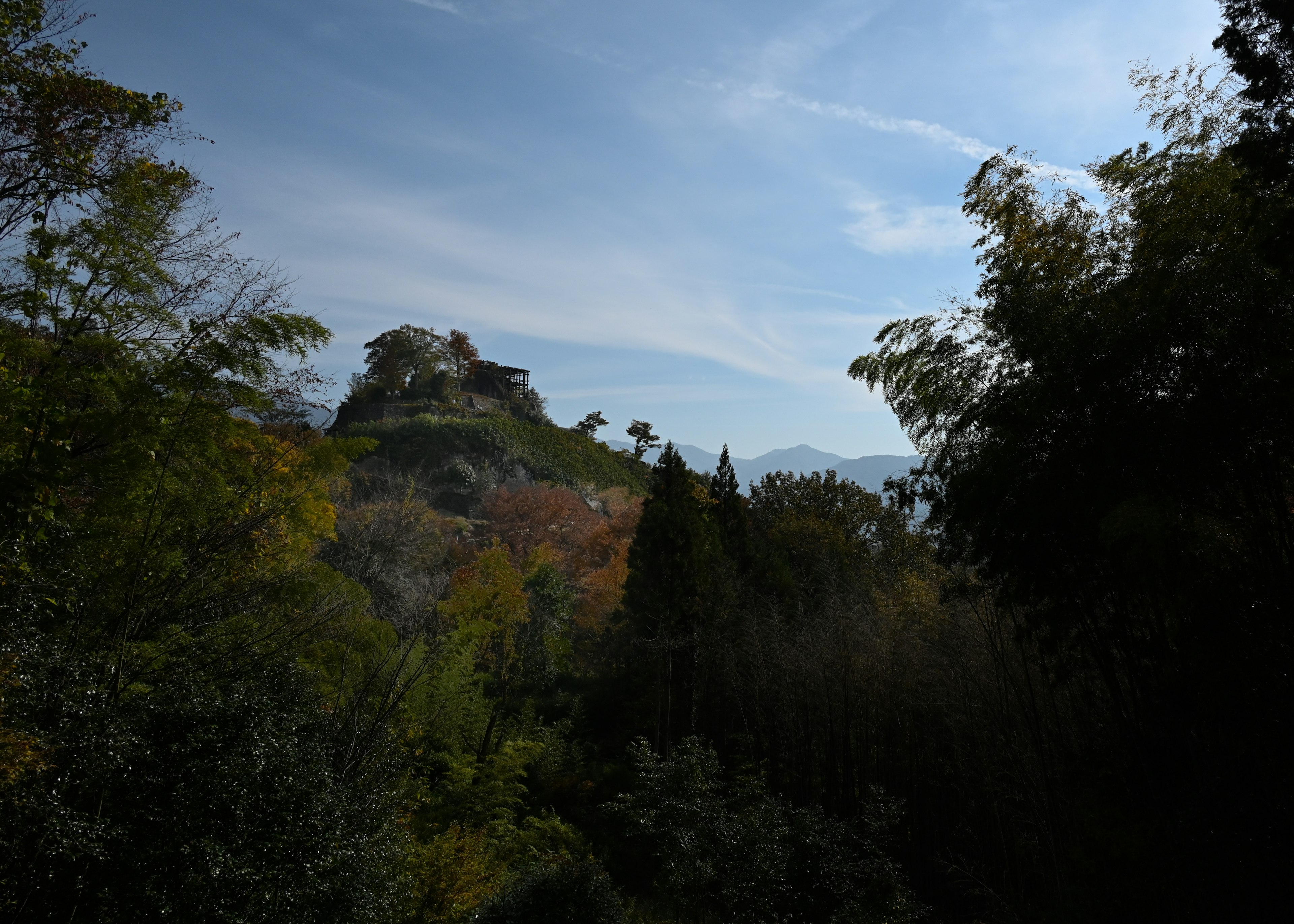 秋の風景の中にある山の上の城と青空