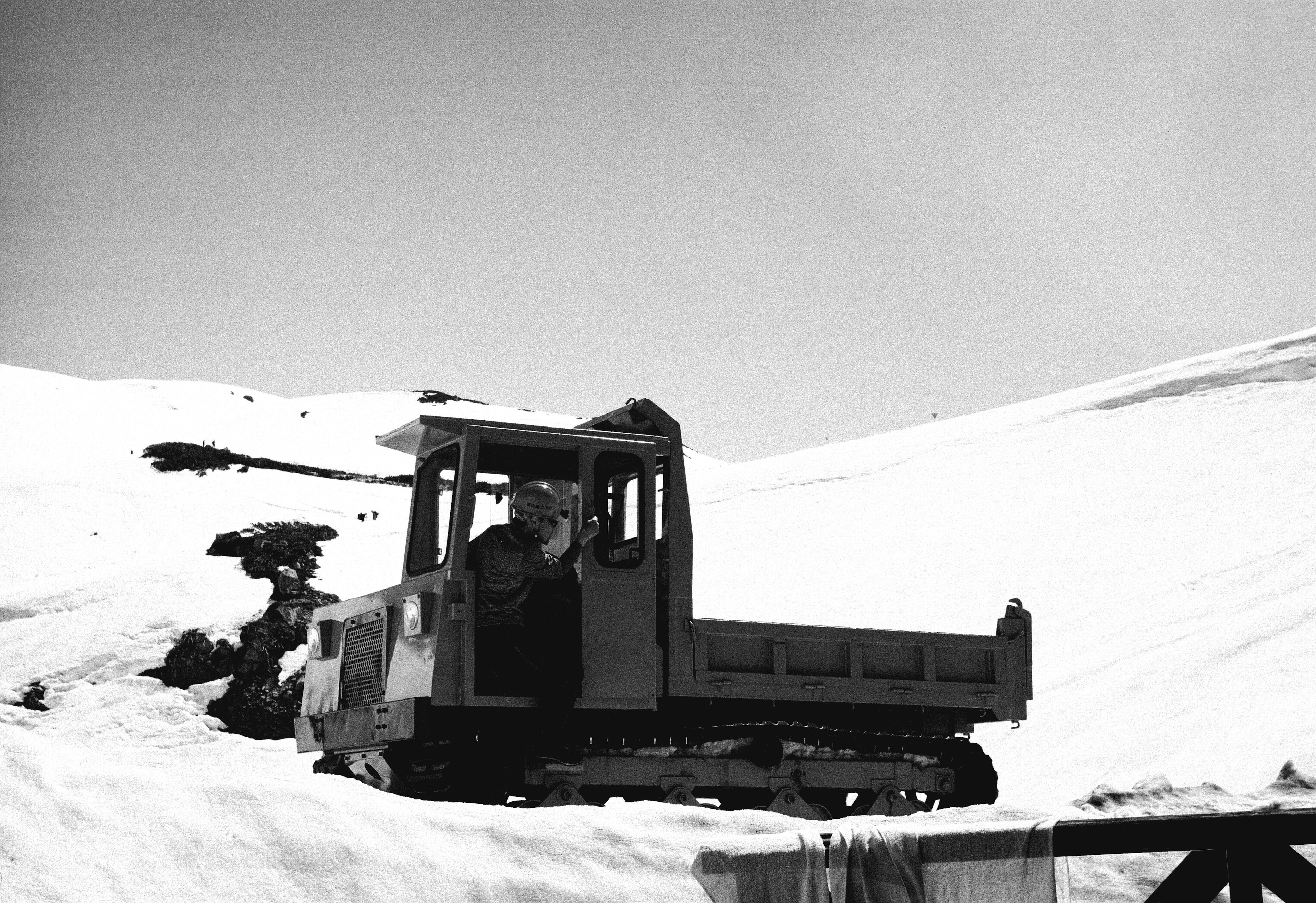 Black and white photo of a snowcat on a snowy landscape