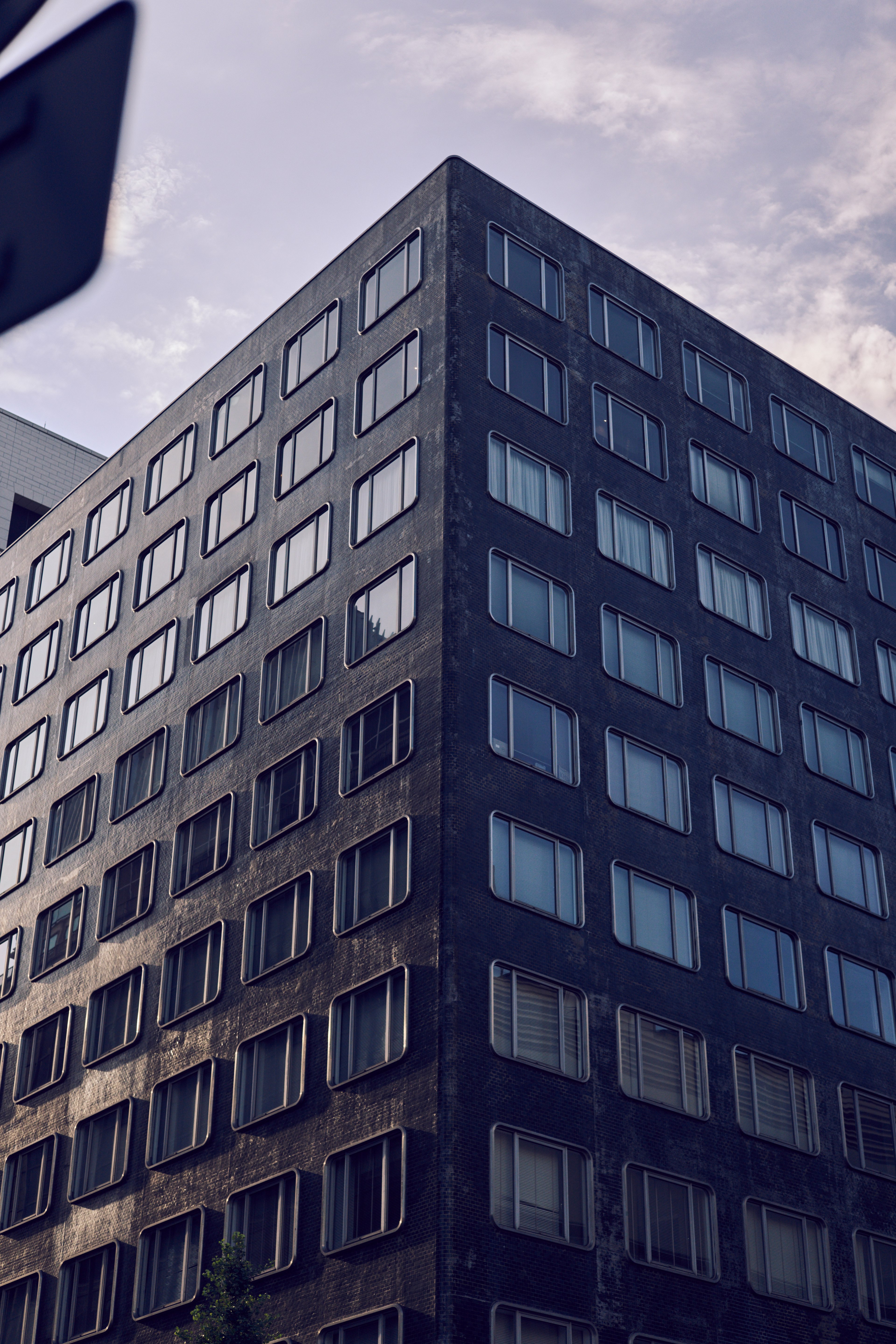 Bâtiment moderne avec une façade noire présentant des fenêtres espacées uniformément