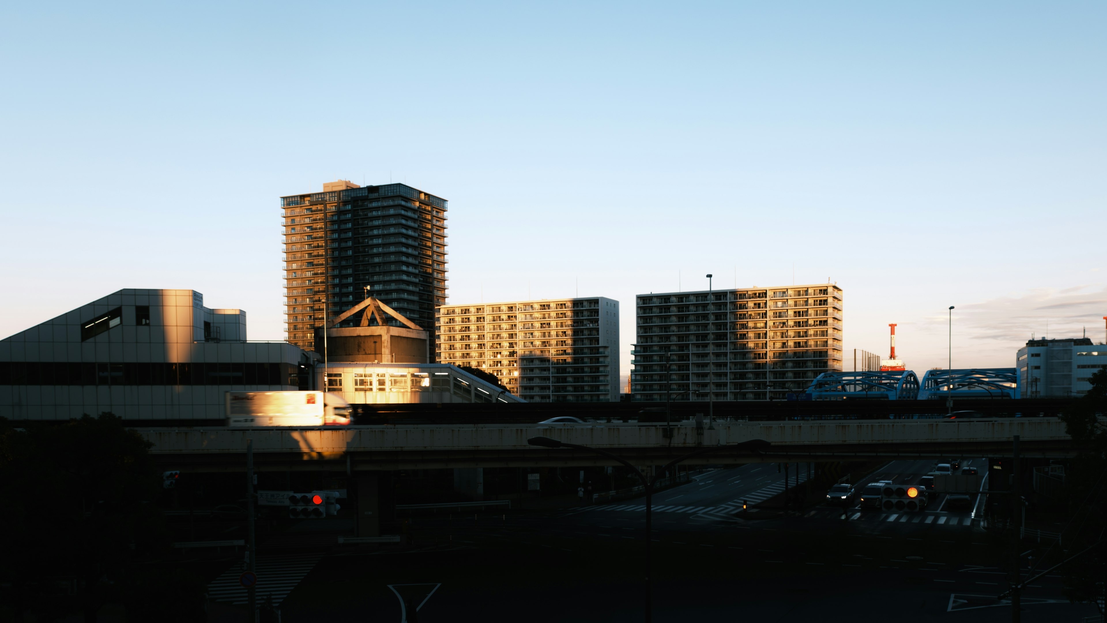 Paisaje urbano al atardecer con edificios altos y estructuras bajas con siluetas hermosas