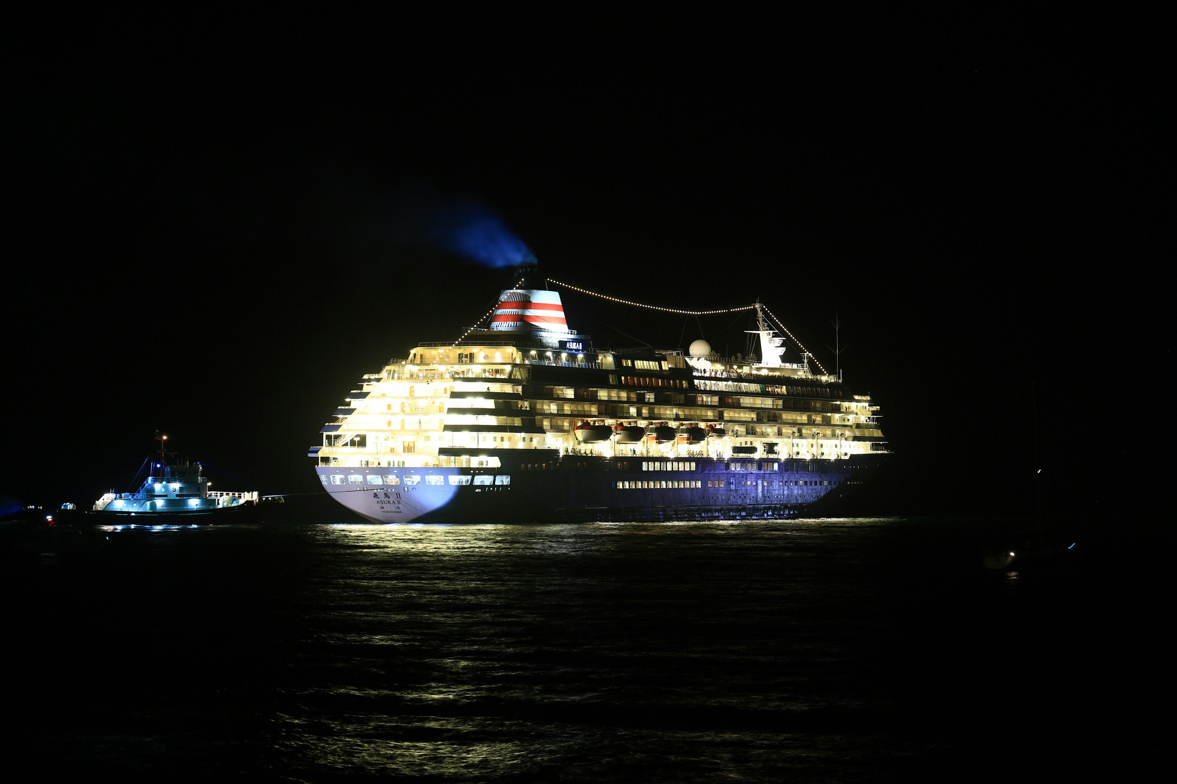 Una lussuosa nave da crociera illuminata di notte che galleggia sul mare