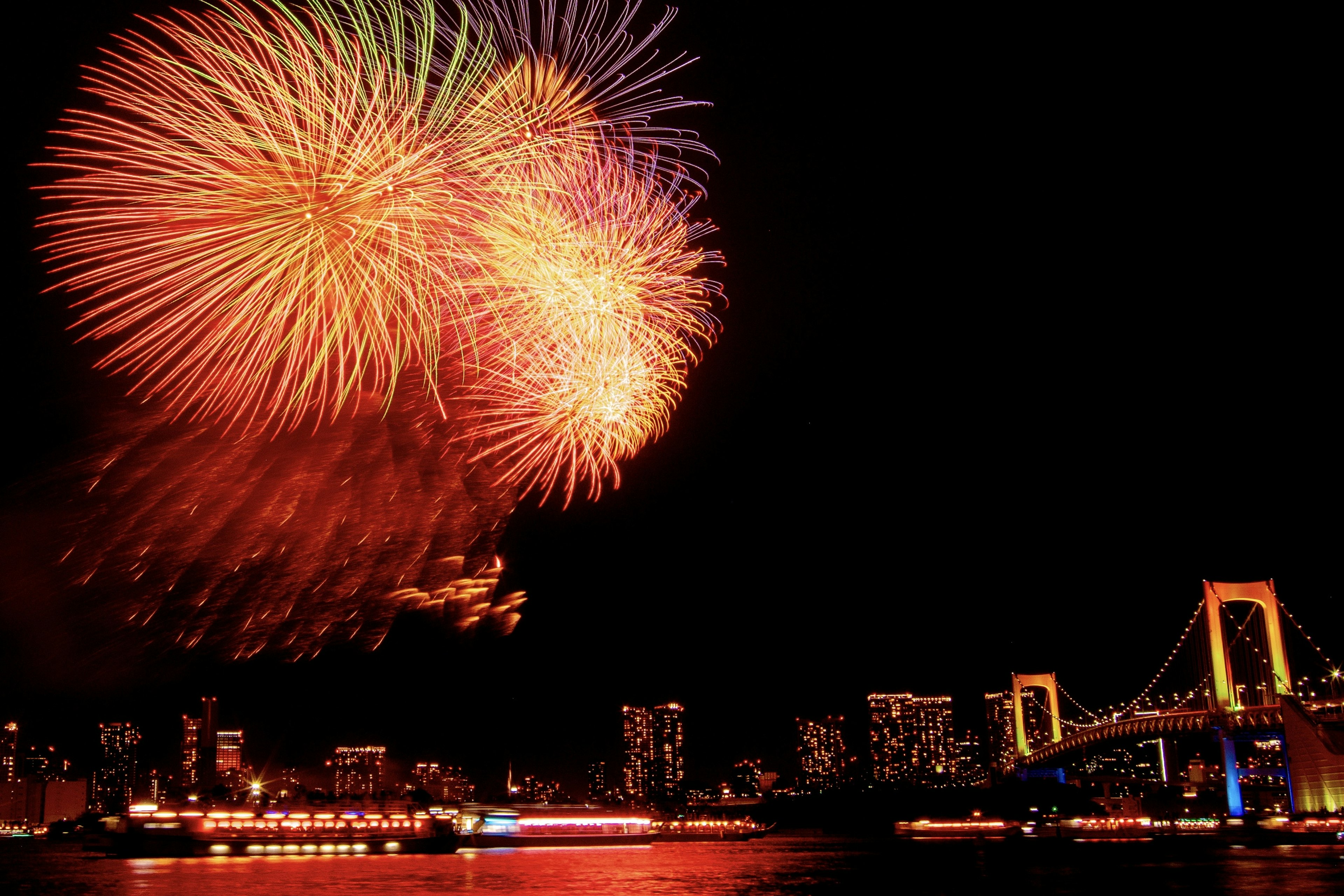 Feuerwerk über der Bucht von Tokio mit der Rainbow Bridge bei Nacht