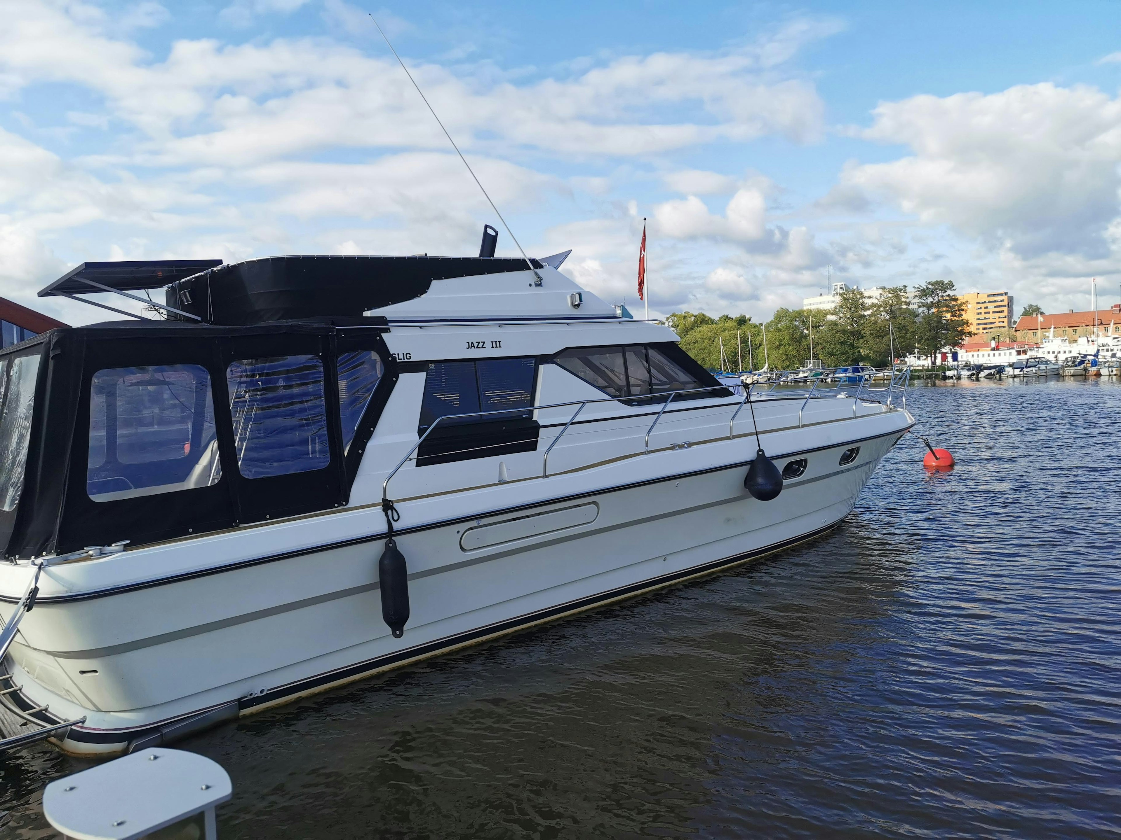 A white boat floating on the water with a scenic background