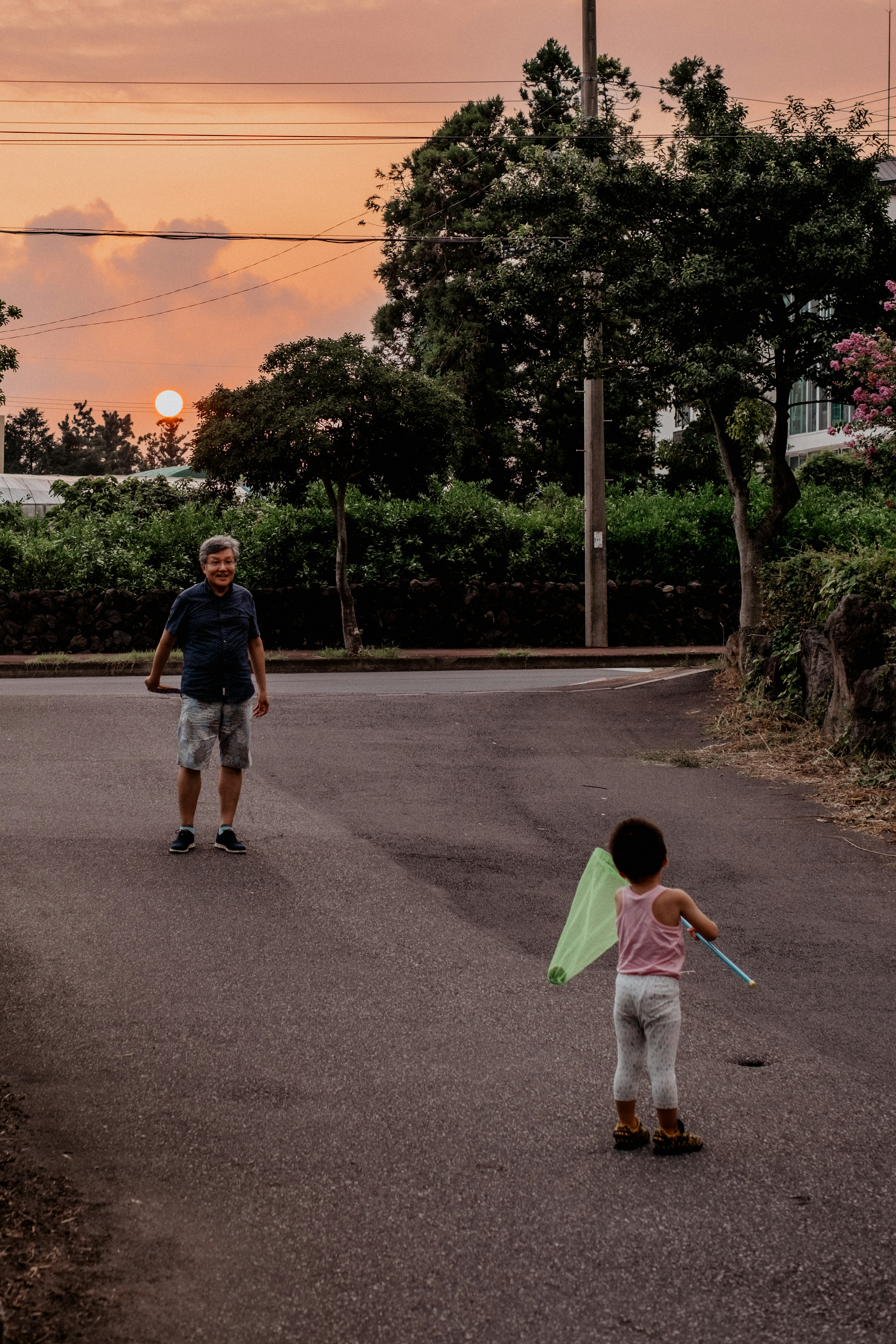 夕焼けの中で遊ぶ子供と大人のシルエット