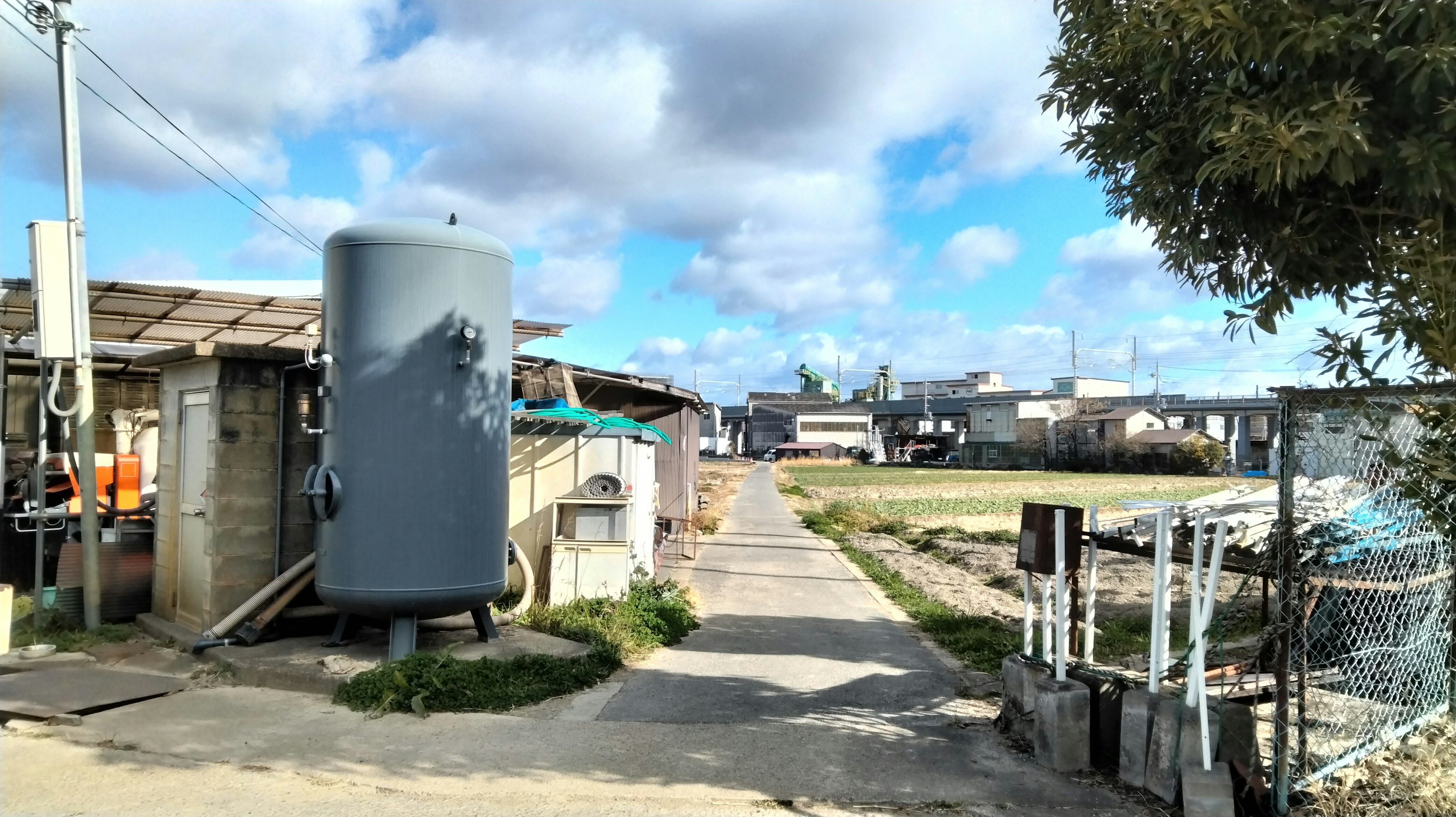 Rural scene featuring a tank and buildings along a pathway