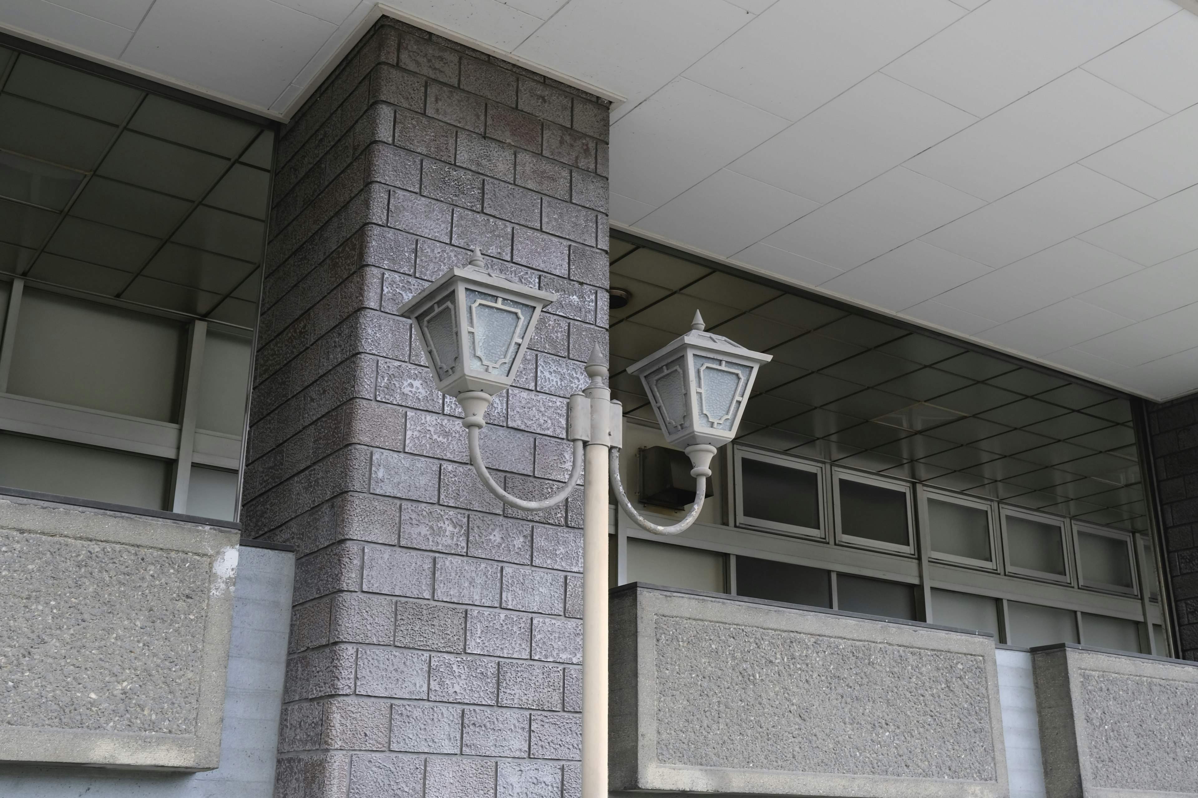 Image of two street lamps attached to the exterior of a building