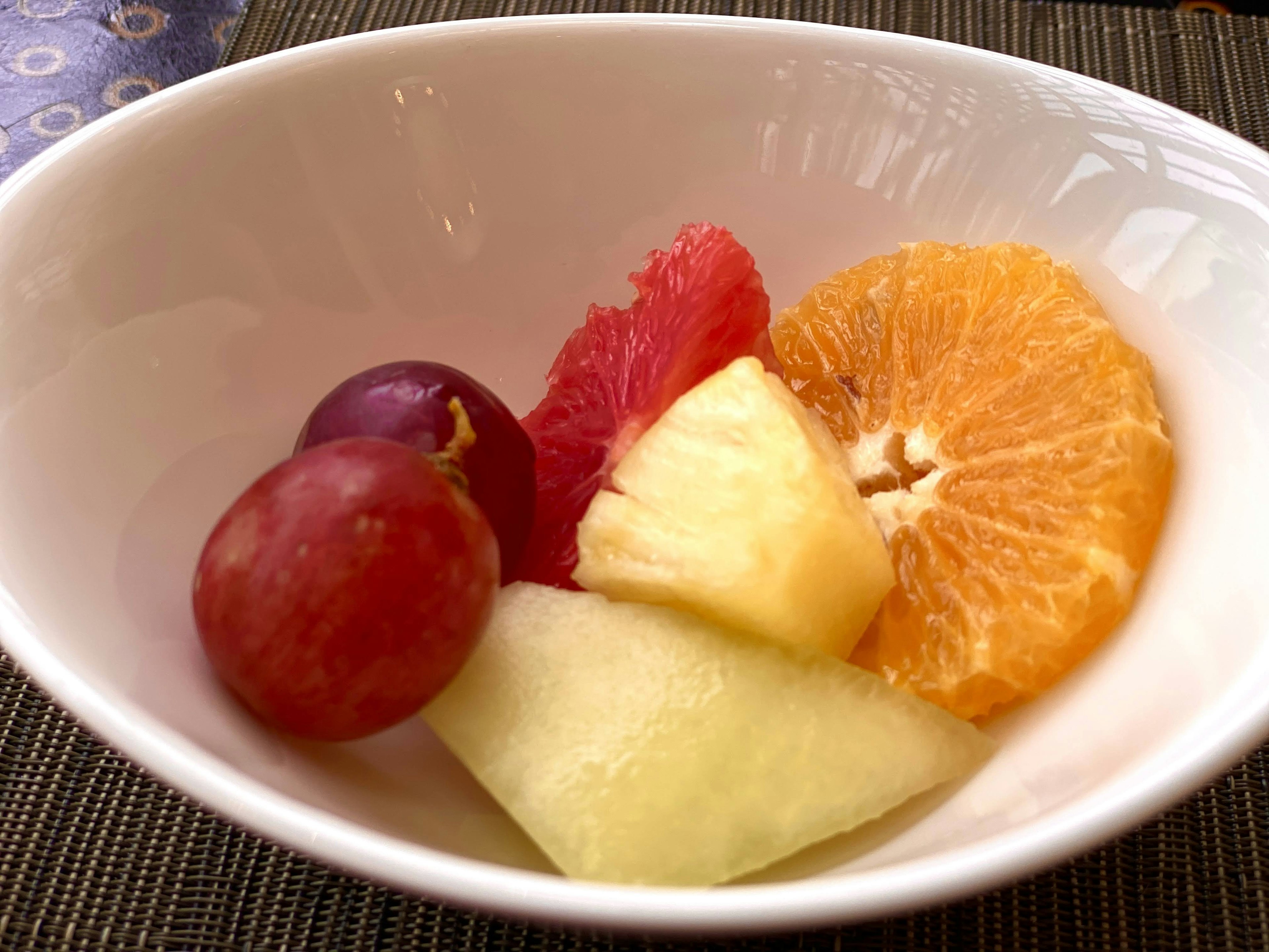 A colorful assortment of fruits in a white bowl