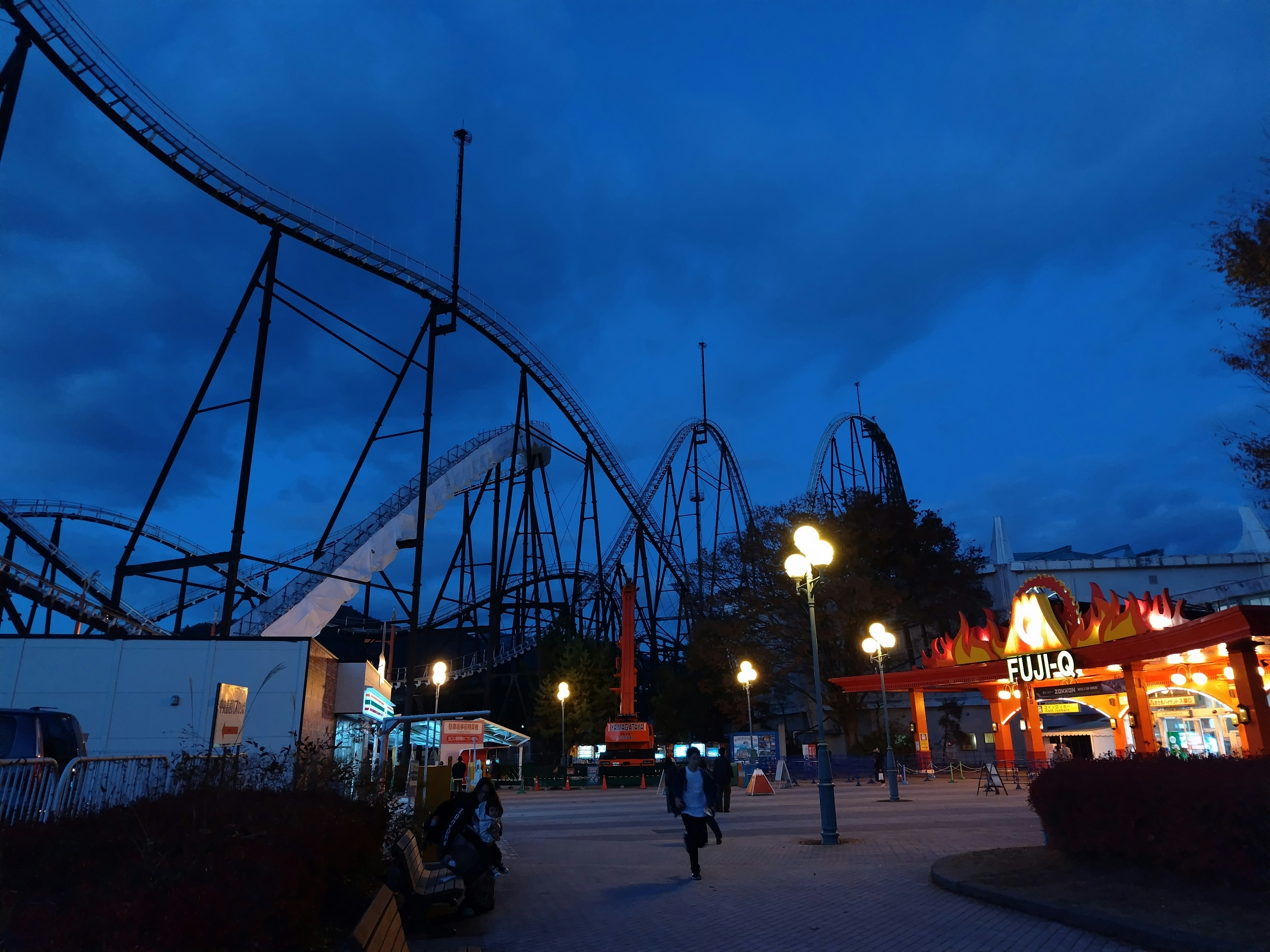 夜の遊園地のローラーコースターと明るい照明