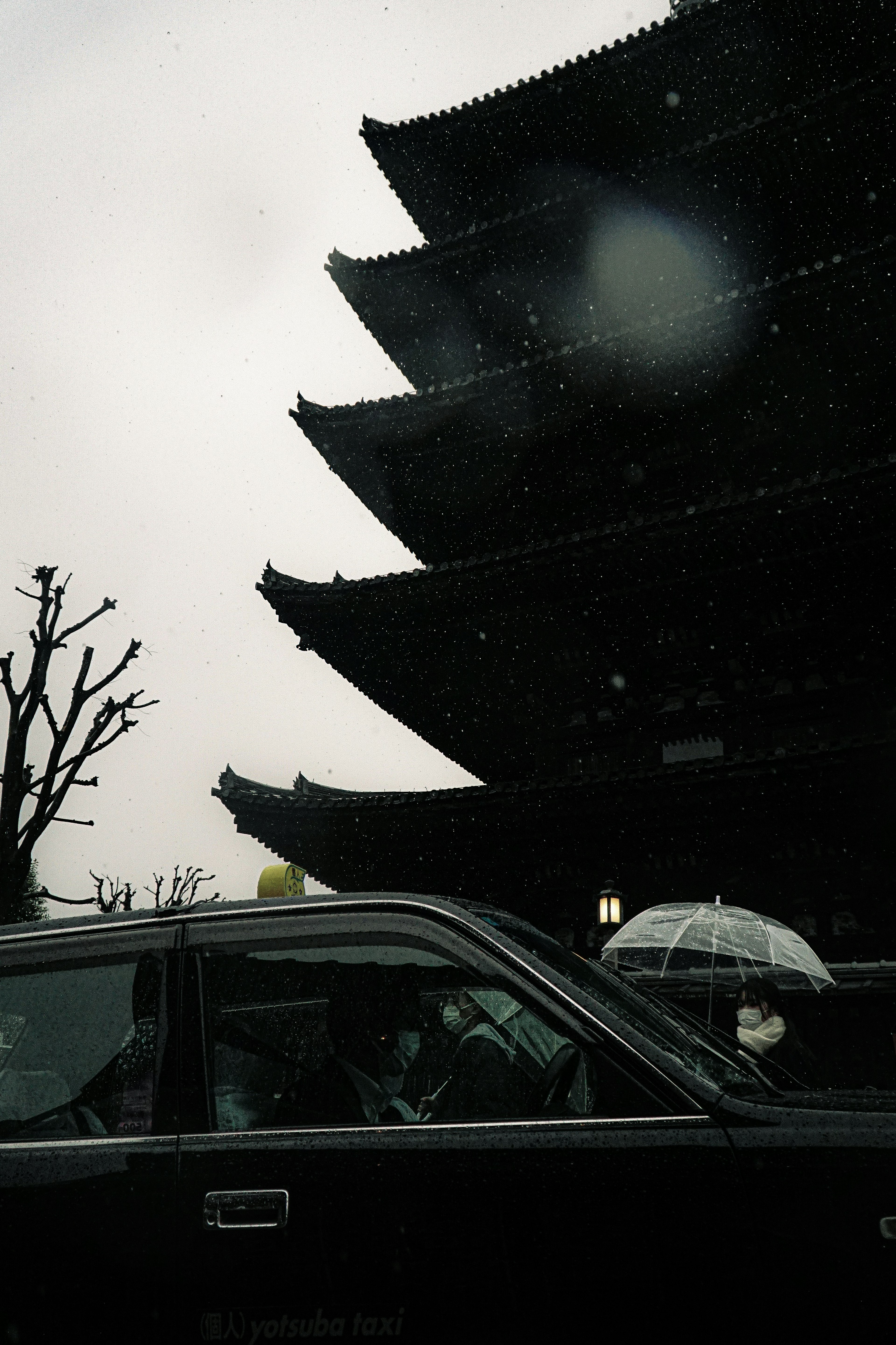 雪の中にある伝統的な日本の建築物と車