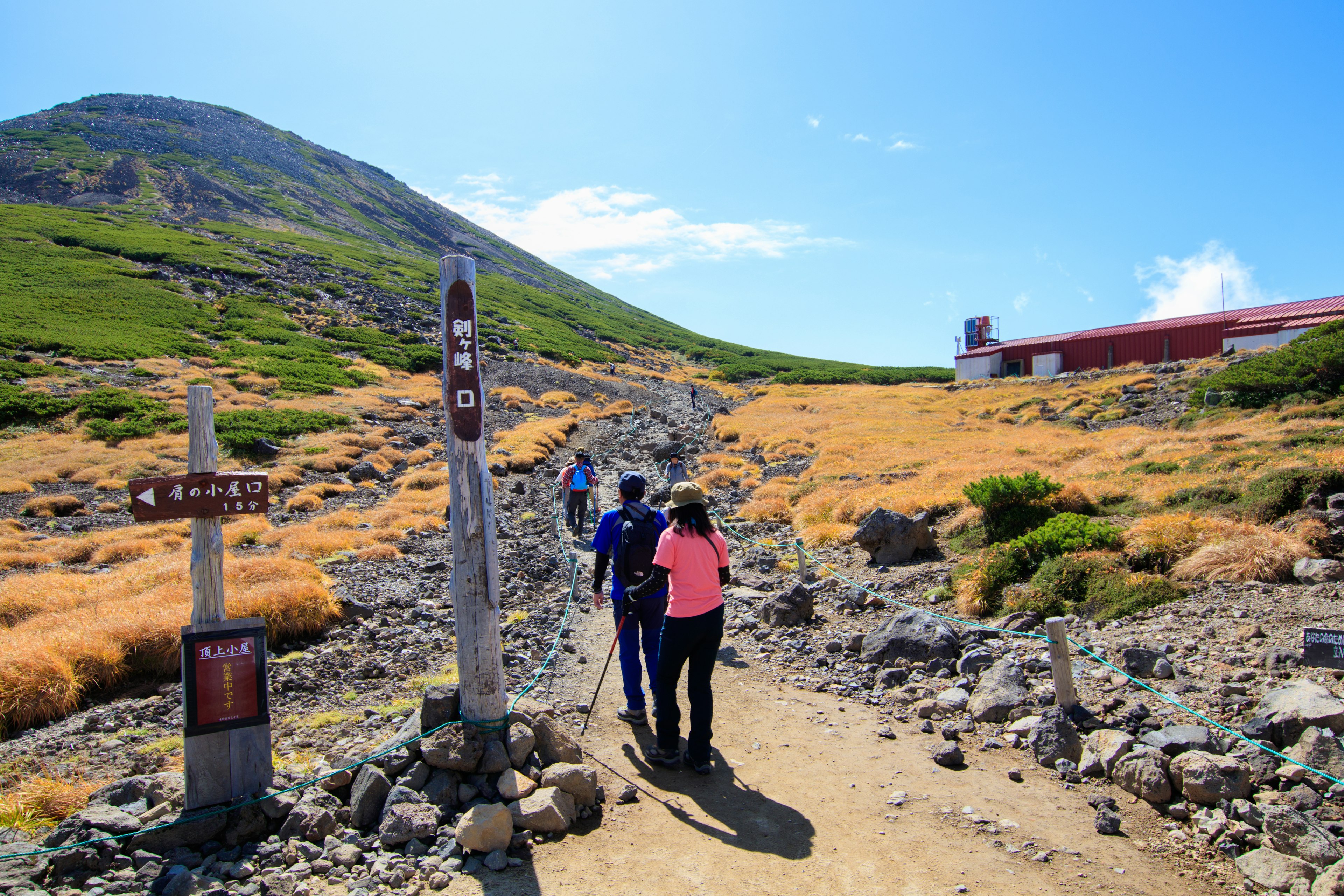 Pendaki berjalan di jalur dengan pemandangan gunung