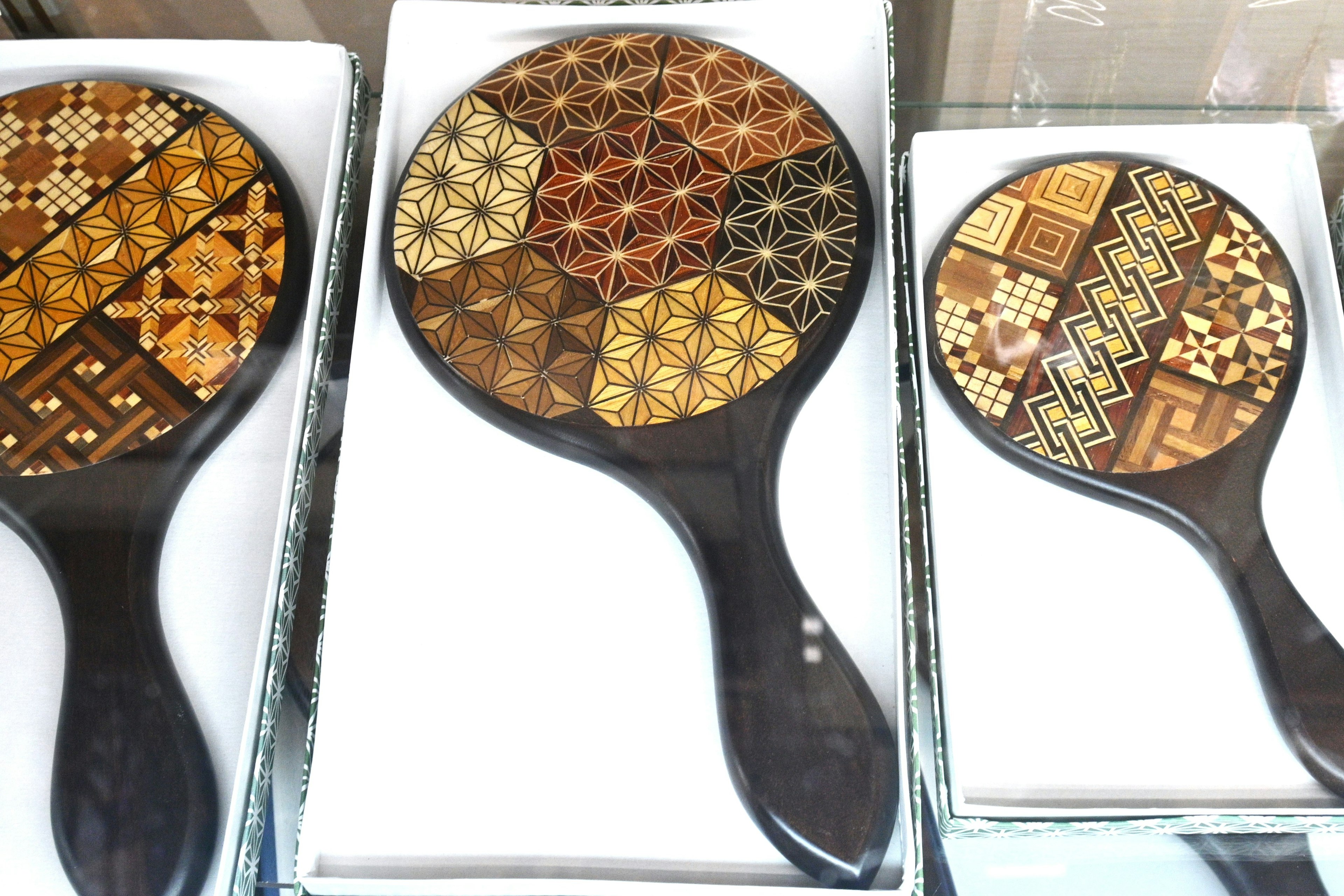 Beautifully decorated wooden hand mirrors featuring various patterns