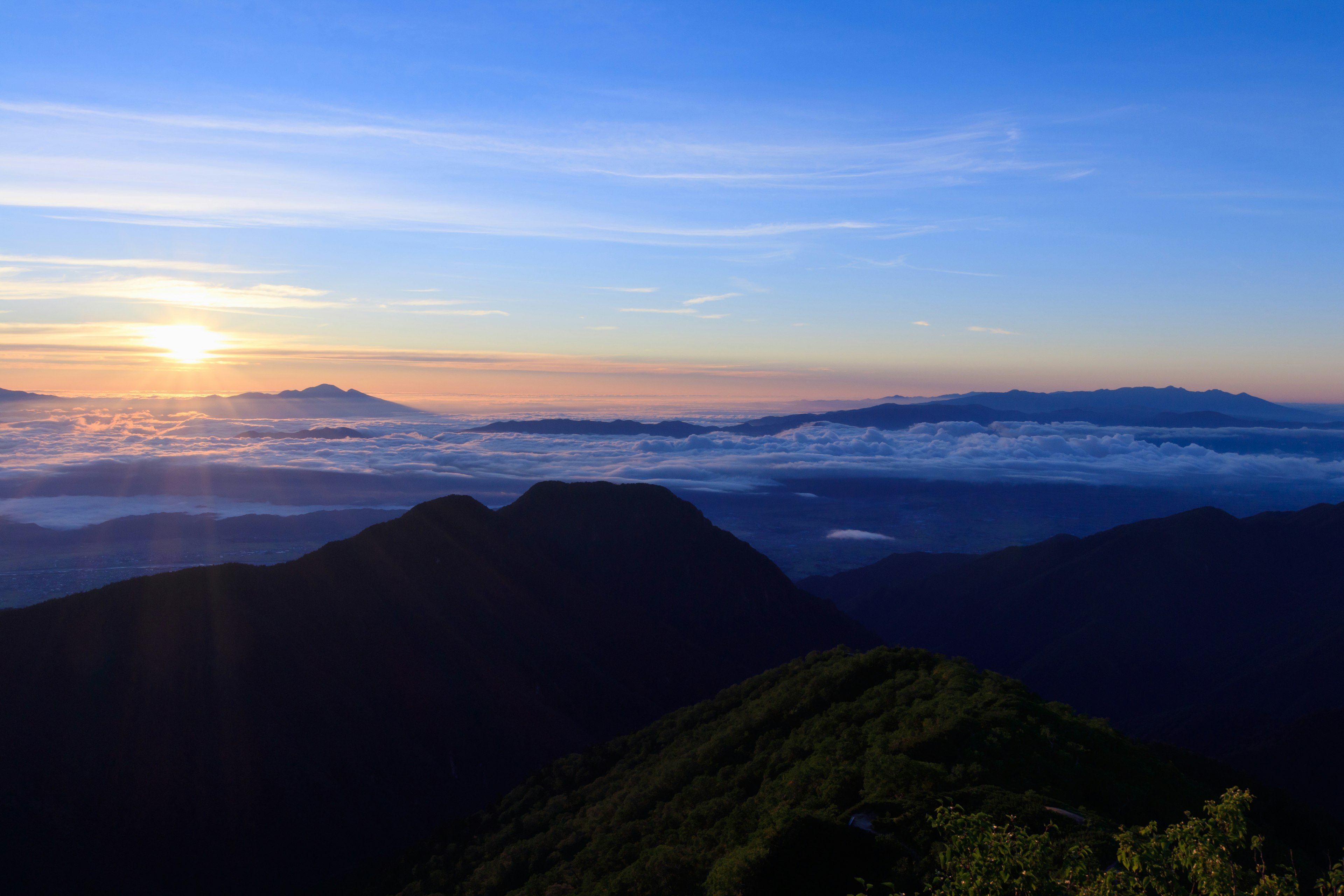 美しい日の出が山々の間に広がる風景